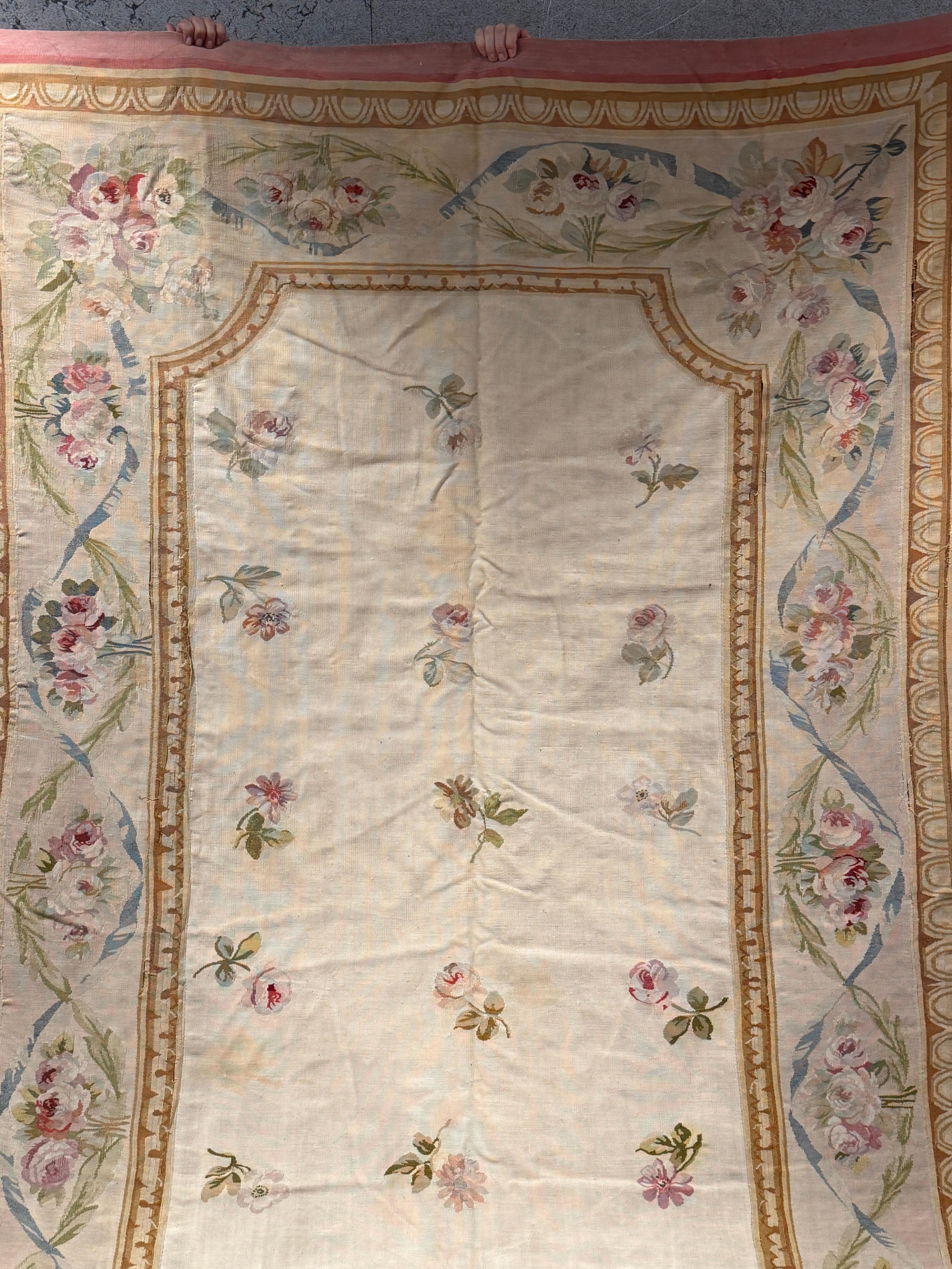 Ce ravissant tapis en tapisserie d'Aubusson, datant d'environ 1870, rayonne de la douce élégance et du raffinement romantique qui caractérisaient les grands ateliers de tissage français du XIXe siècle. Sa délicate palette de pastels, centrée sur des