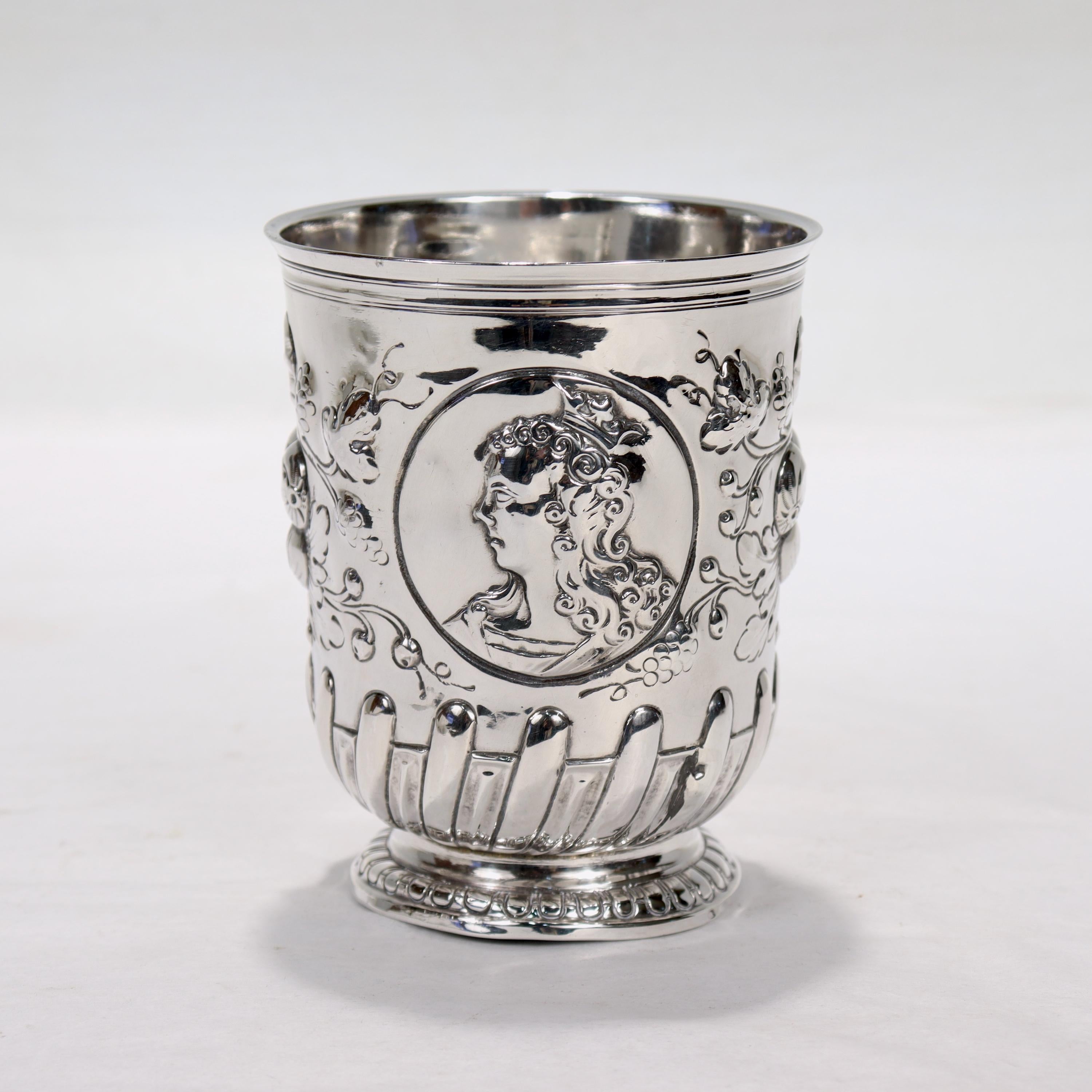 A fine antique sterling silver beaker or cup.

With a stepped rim, profiles of a man and a woman front and verso (possibly a king and queen), and repoussé decoration throughout with fruit and foliage above gadrooning and a thin plugger formed