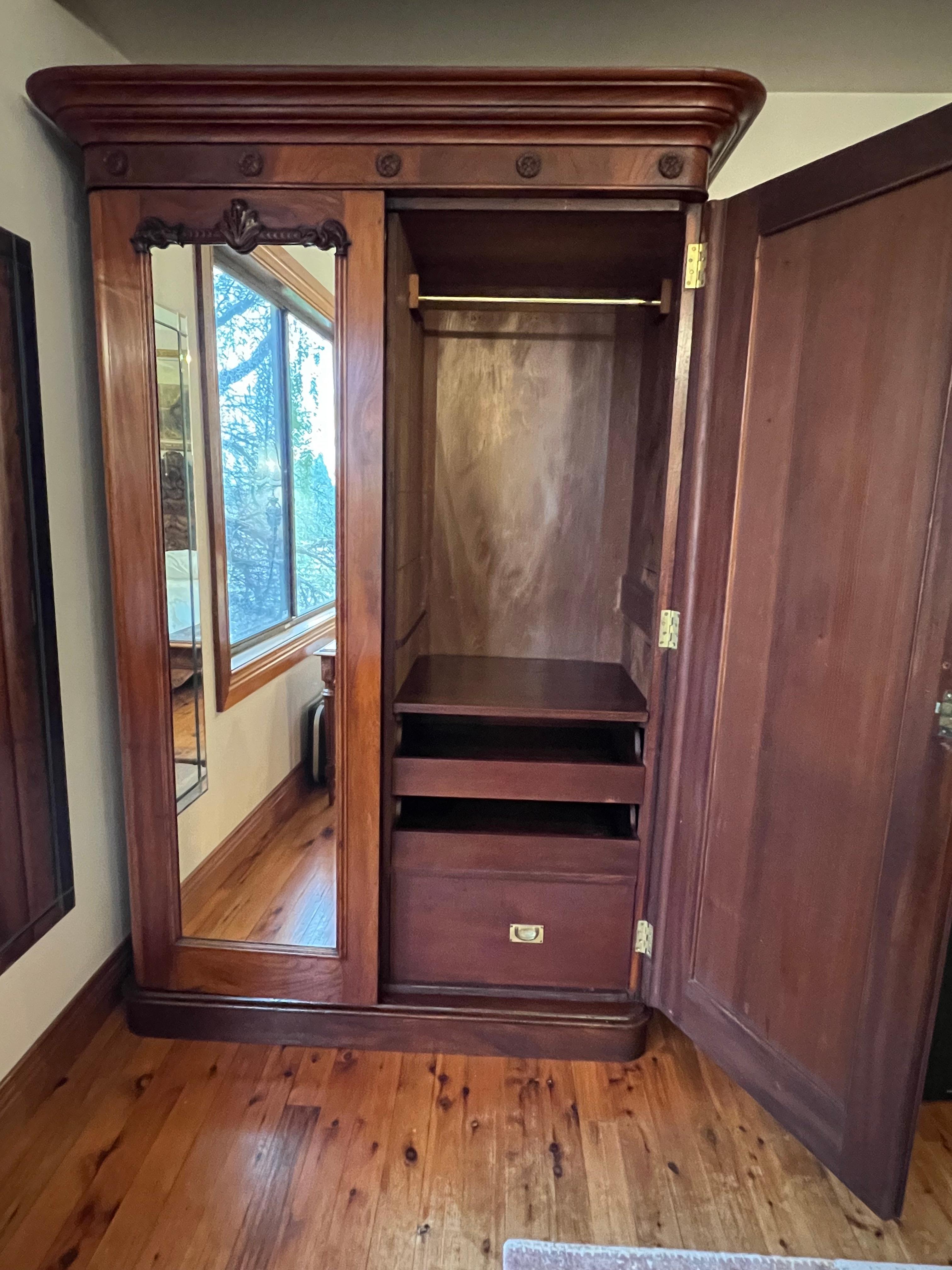 Double door mirrors with top carving detail, top cornice, very deep cupboard, with two hanging sides, four pull out drawers, two larger bottom drawers, very grand wardrobe. 

Circa: 1860 

Material: Cedar

Country of Origin: