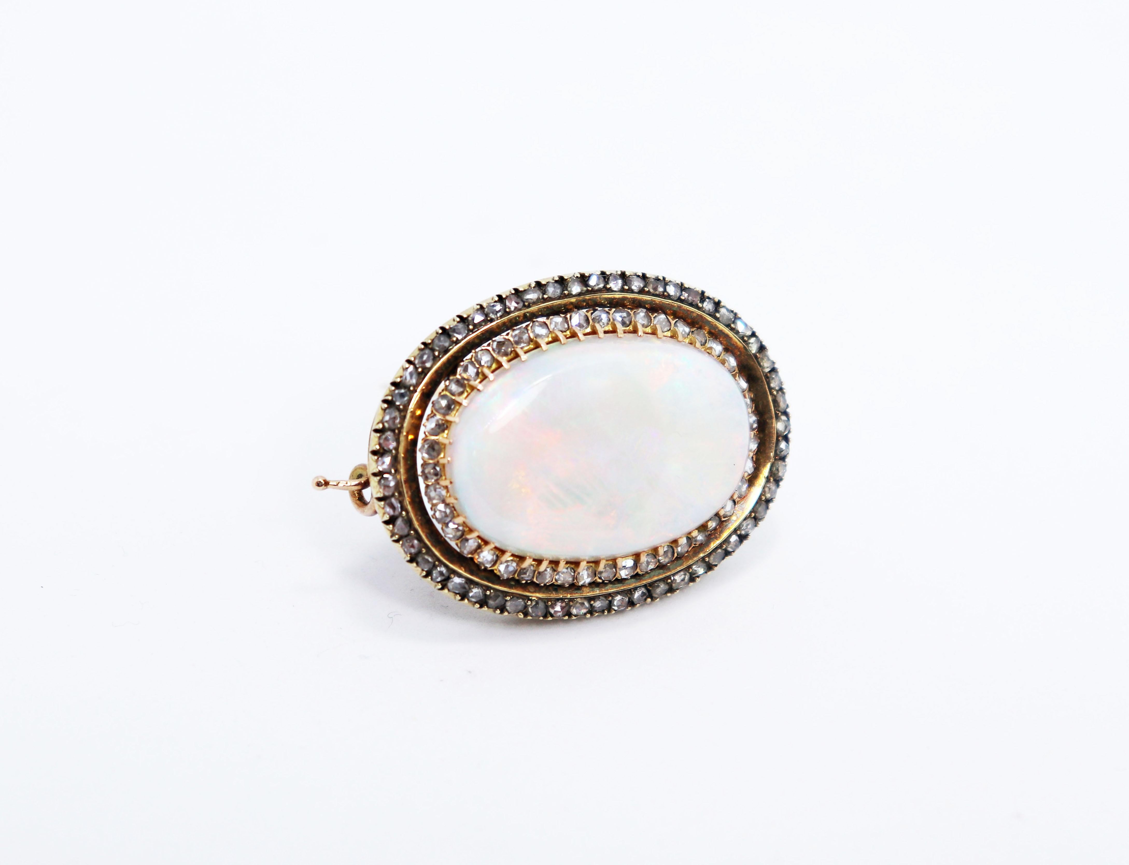 Beautiful handmade antique brooch set with an impressive Australian opal with an approximate weight of 35.00 carats measuring 20x30mm in a 43 claw setting. The opal is surrounded by two rows of rose cut diamonds, coronet set,  totalling to