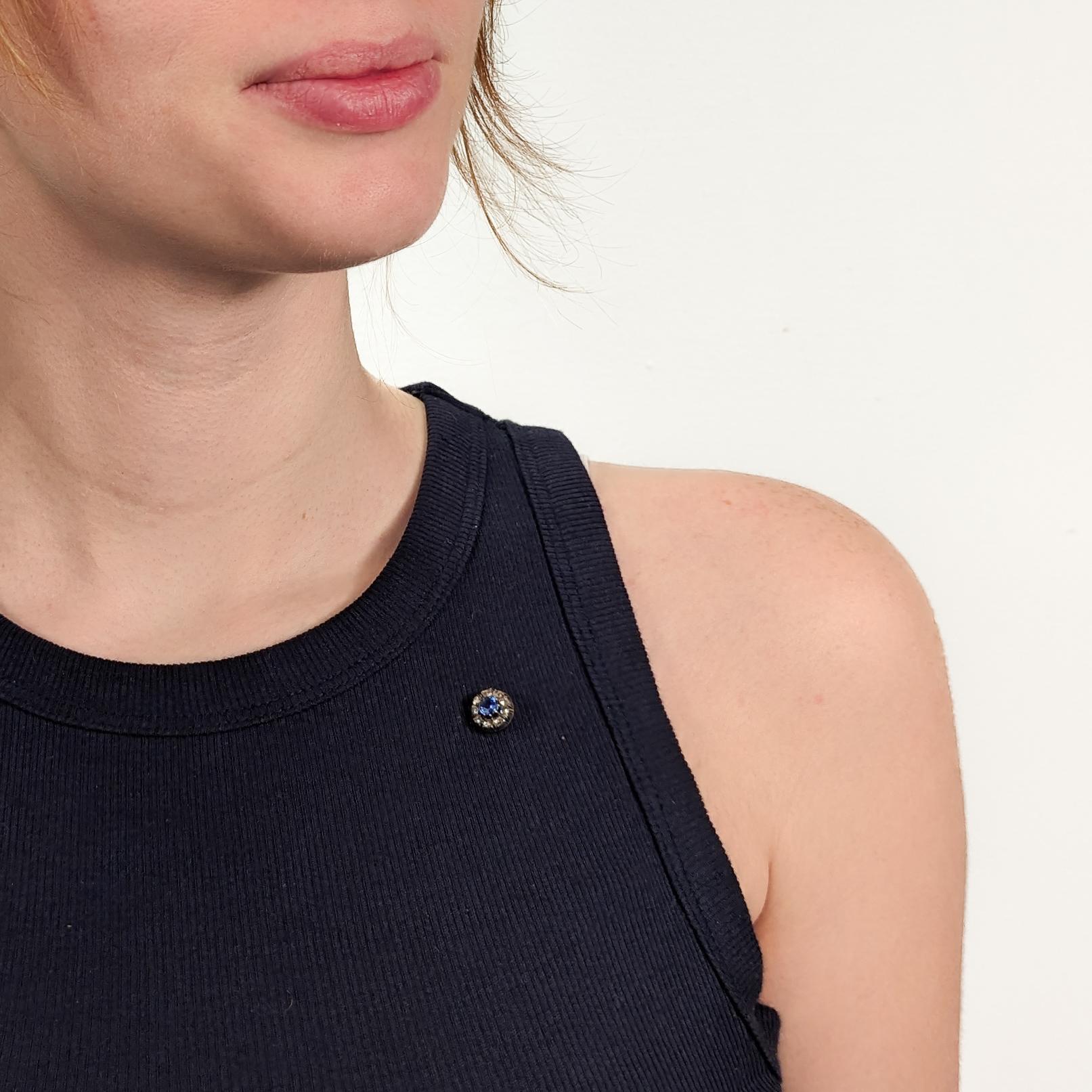 A fine antique Austrian stick pin.

In 14 karat rose gold mounting with a silver top.

Center set with a circa 0.6ct round mixed cut synthetic blue sapphire (transparency: transparent, color hue: blue, saturation moderate) and surrounded by 9 rose