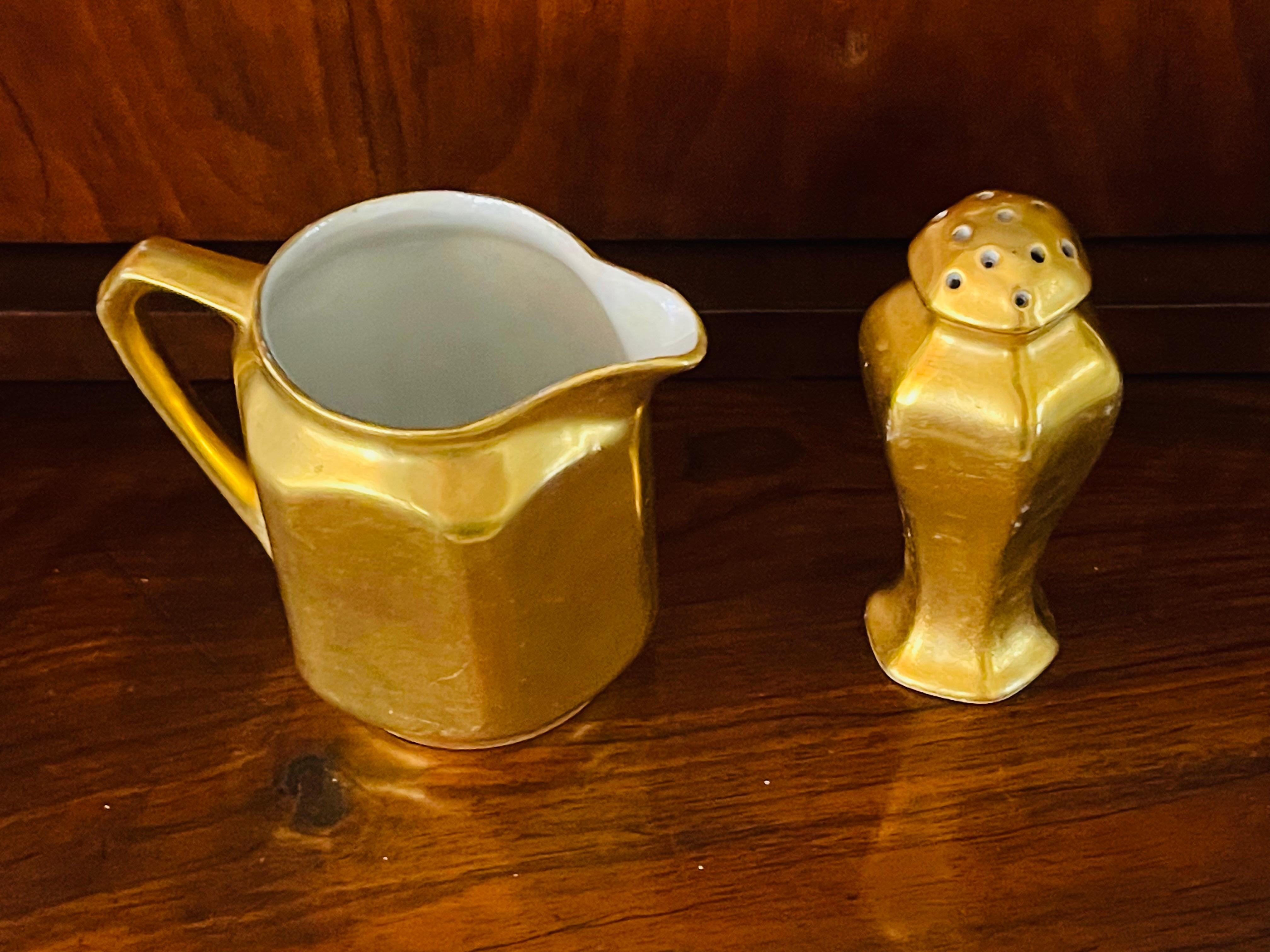Zwei antike Art-Déco-Geschirrteile - ein Milchkännchen und ein Salzstreuer - aus österreichischem Porzellan.