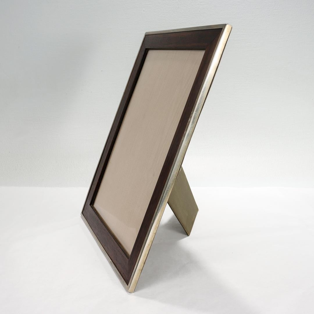 A fine antique early 20th century Austrian picture frame.

Comprised of a silver plate mounted dark walnut wood frame and a damascened silk back and interior.

Mounted with clips to the reverse to hold the back in along with integrated hooks for