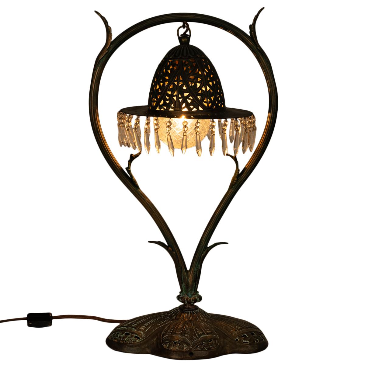 A very handsome antique Austrian Art Nouveau bronze table lamp with glass prisms, circa 1900.
The lamp of organic form with a 'balloon' shaped harp, that is ribbed and decorated with six stylized leaves. From the top of the harp hangs a pierced &