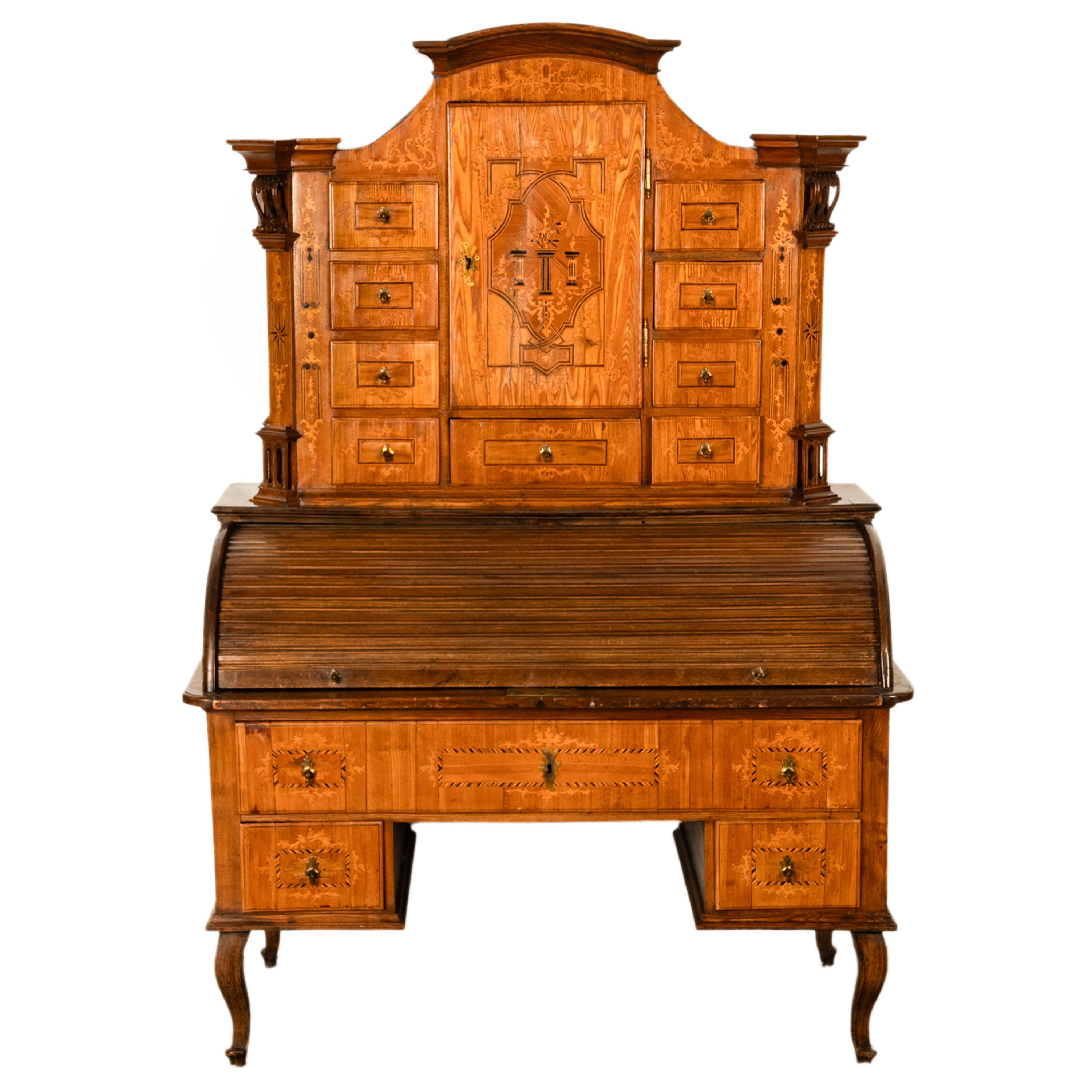 Ein seltener und ungewöhnlicher antiker böhmischer Tabernakelschrank mit Intarsien aus Ulmenholz, Österreich, um 1820.
Der Schrank in zwei Abschnitte, die oben mit einem gewölbten Giebel, die Seiten des Gehäuses sind gekantet und haben geschnitzt