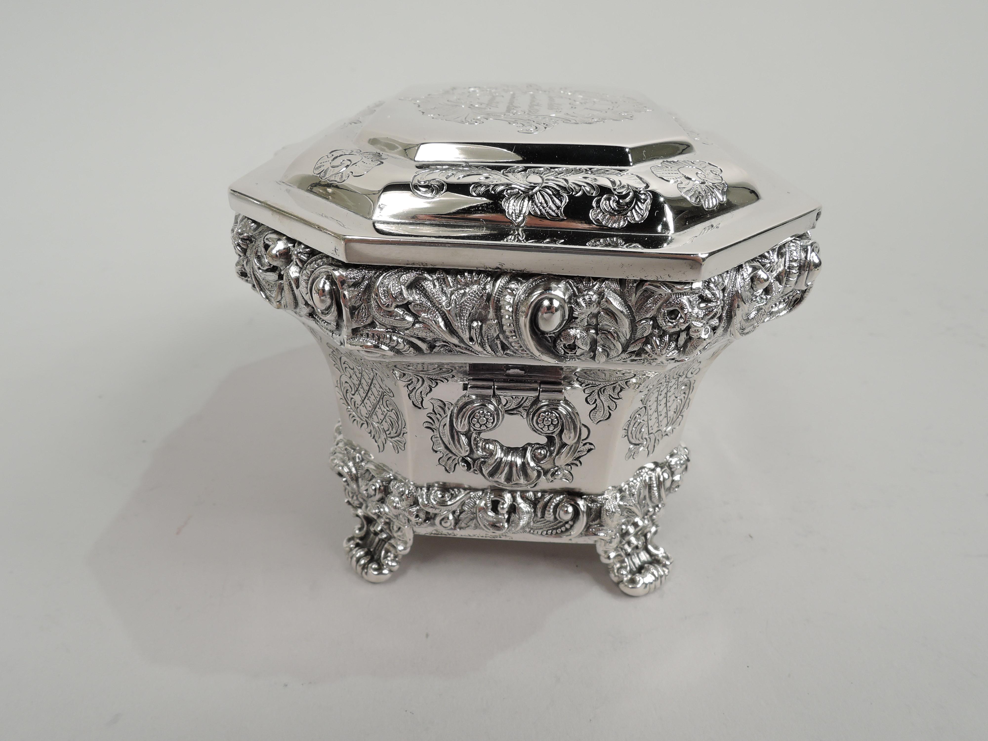 Austrian Biedermeier Classical 812 silver casket. Rectilinear with tapering sides and chamfered corners. Cover hinged, tabbed, and stepped. Applied scroll and flower rims. Engraved leaves and flowers. Loose-mounted c-scroll end handles. Corner shell