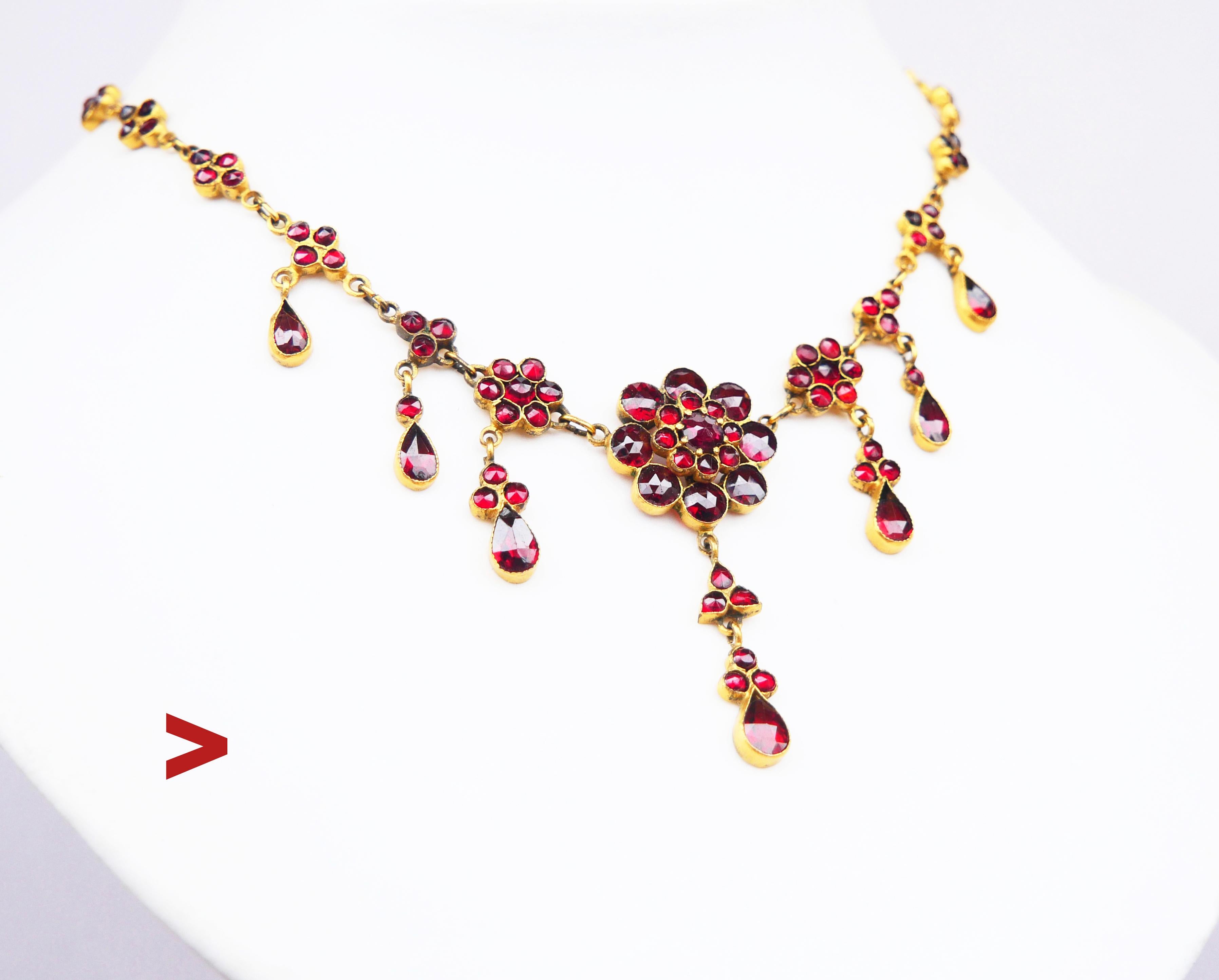 Bohemian ca. 1900 s-1920's Austrian / Bohemian Garnet Necklace. No hallmarks.

All metal parts made of gilded Silver. All blood Red Bohemian Garnets are rose cut and bezel set. Central flower and drop shaped dangles have open backs, all other parts