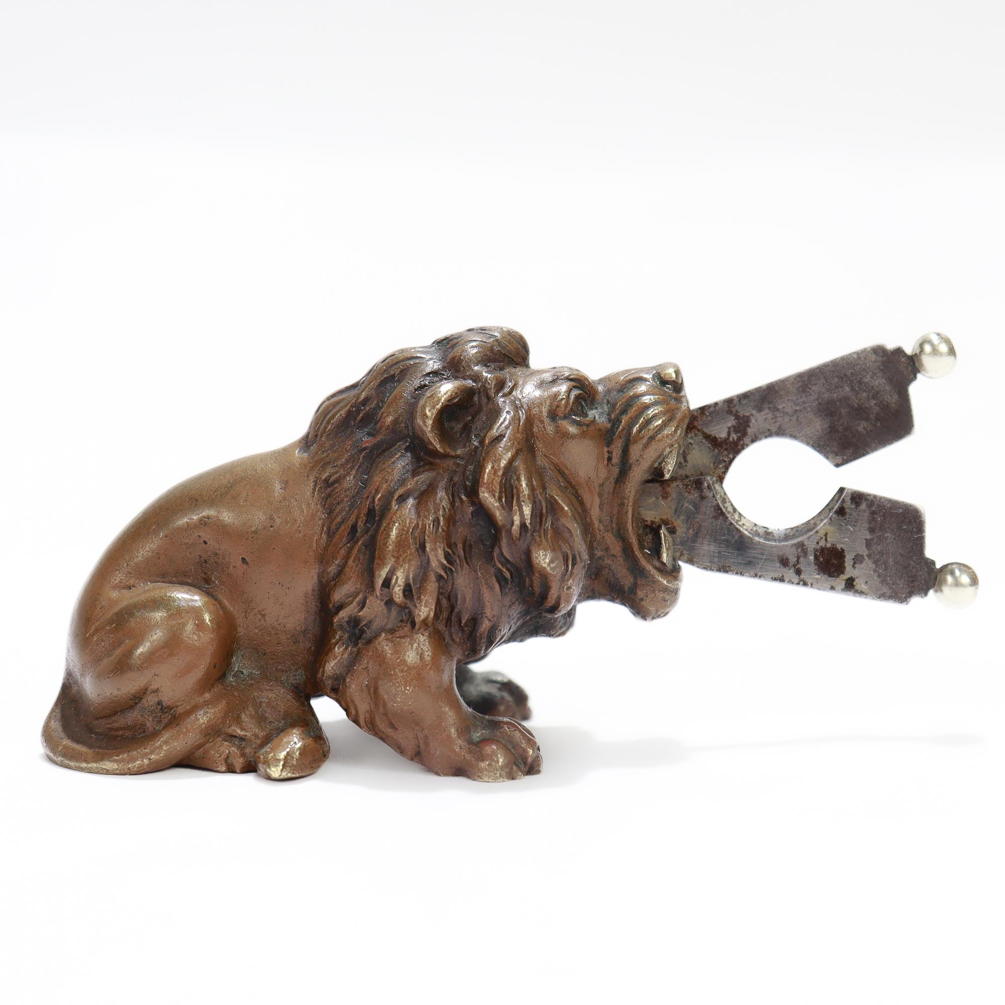 A fine antique Austrian pair of cigar nips.

In the form of a seated lion with an open mouth.

Between the lion's jaws are a pair of ball finials attached to a pair of retracted steel cigar nips. To extend the ball ends are squeezed together and the