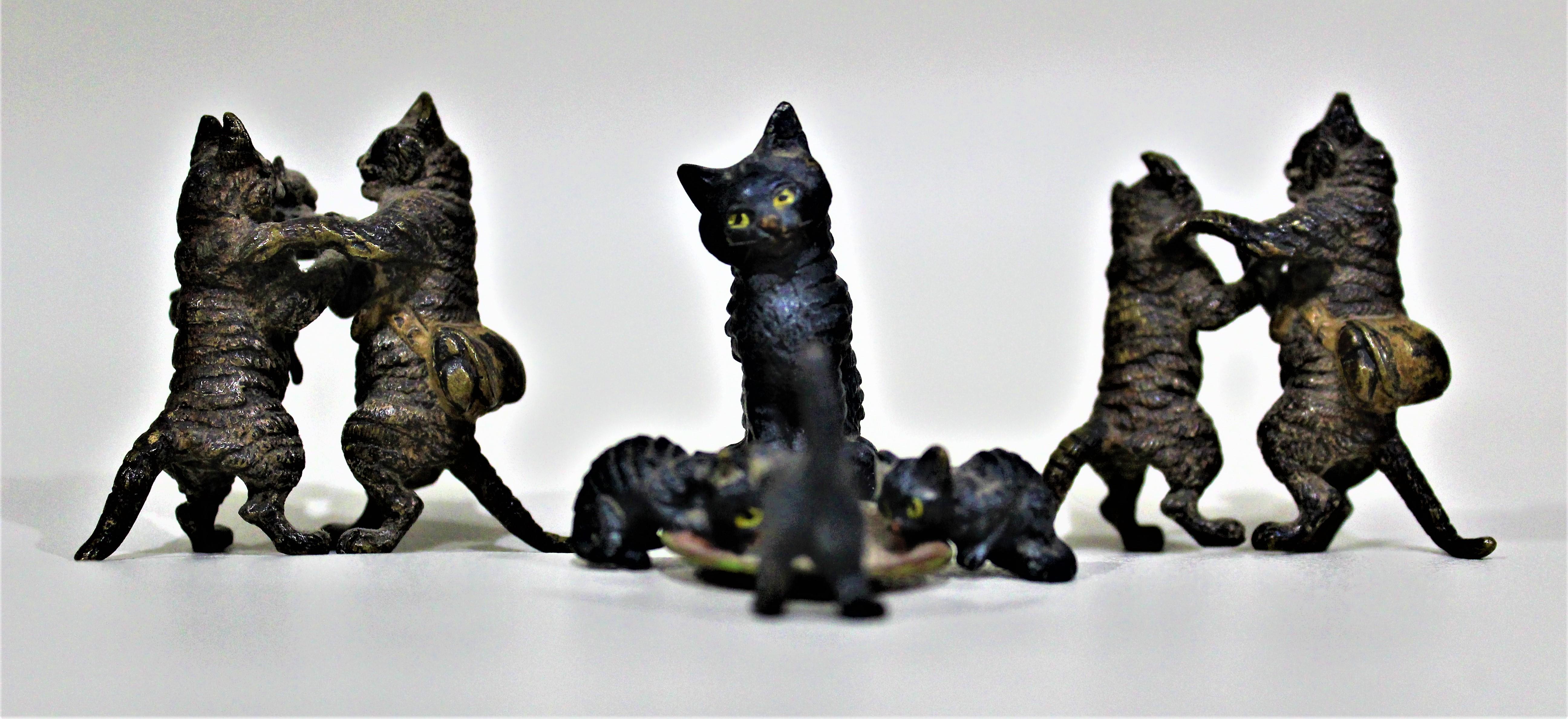 Lot of three ornately cast and cold-painted antique Austrian bronze miniatures of whimsical cats; two sculptures depicting dancing and the other portrays a mother with her kittens sharing a bowl of milk. These figurines are highly detailed cast and