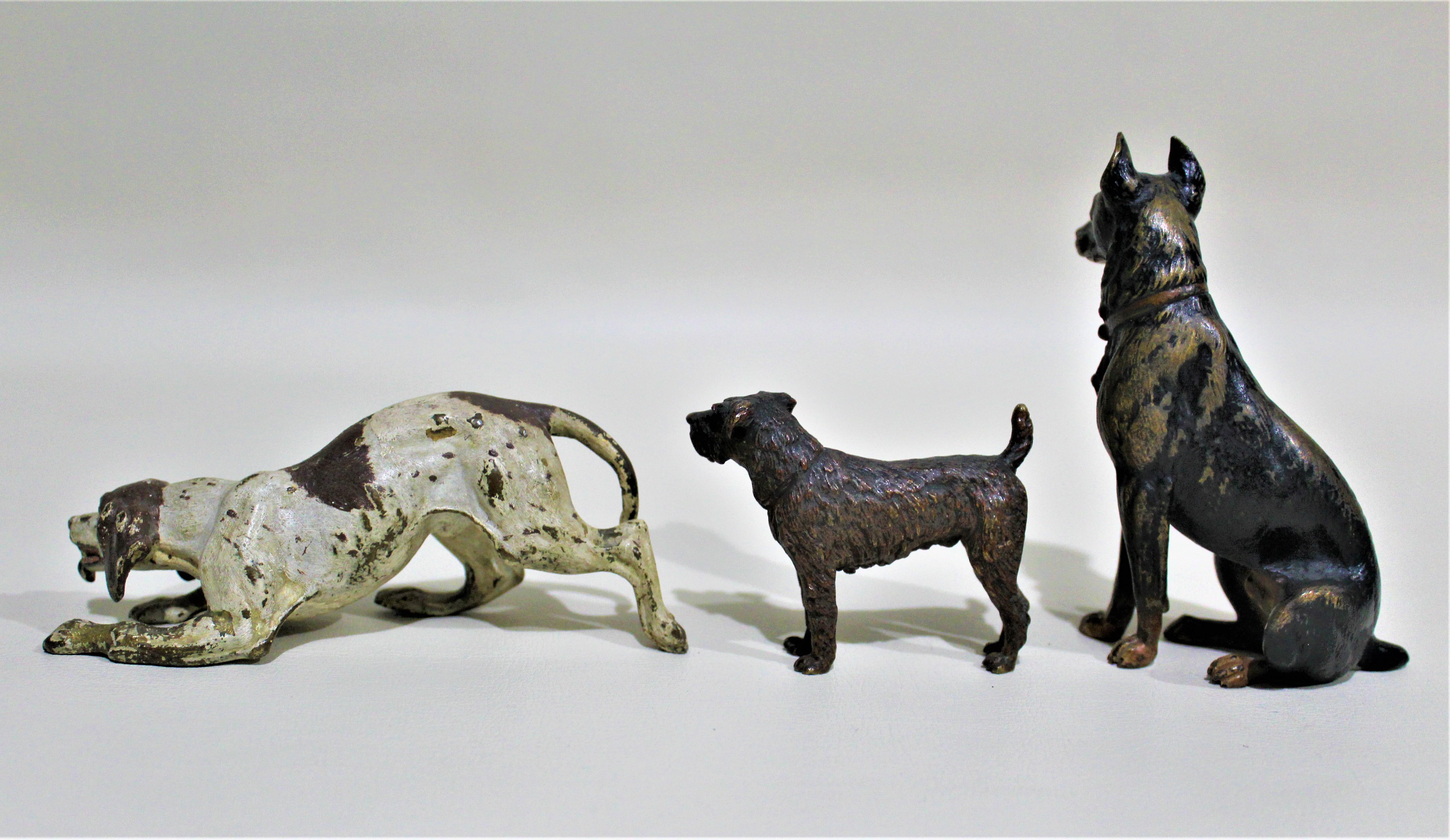 Antique Austrian miniature cast and cold painted bronze sculptures of three dogs presented in one lot, dating from the 1900s-1920s time period. Each figurine is ornately cast and painted in a realistic style.

Approximate dimensions of figures