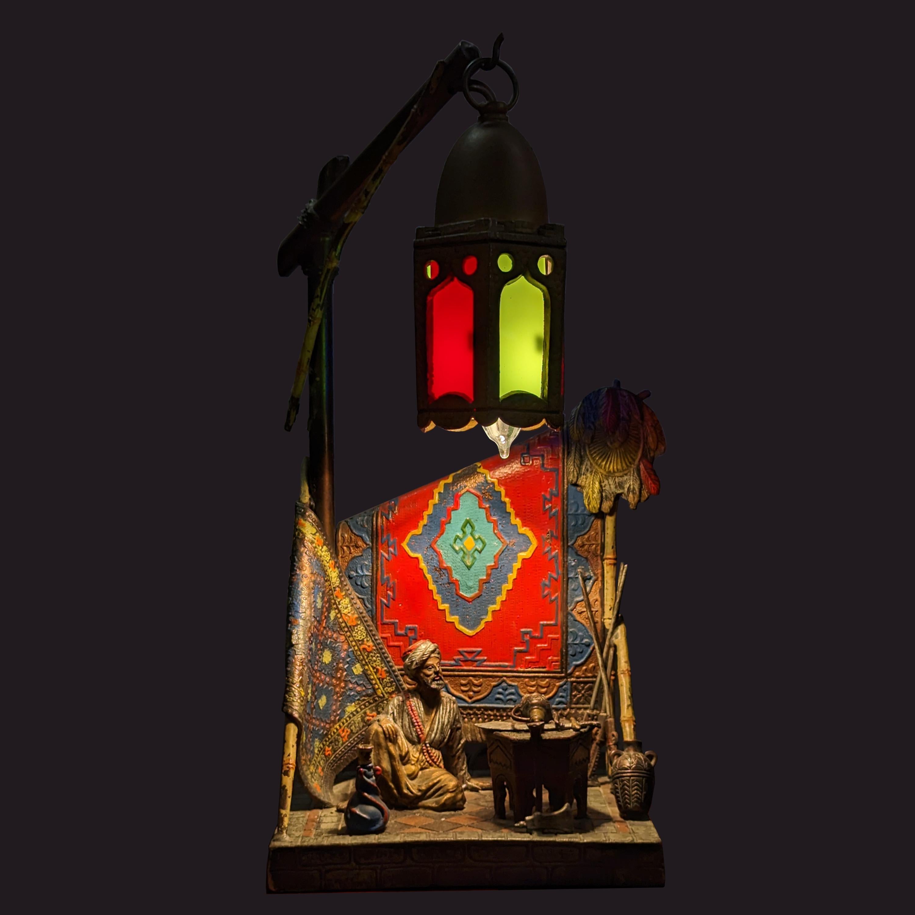 A good antique Austrian cold-painted bronze/spelter Franz Bergmann style Arab carpet seller lamp, circa 1920.
The lamp has just been professionally rewired to code. The lamp depicts a seated Arab carpet seller with a lamp above him, behind a