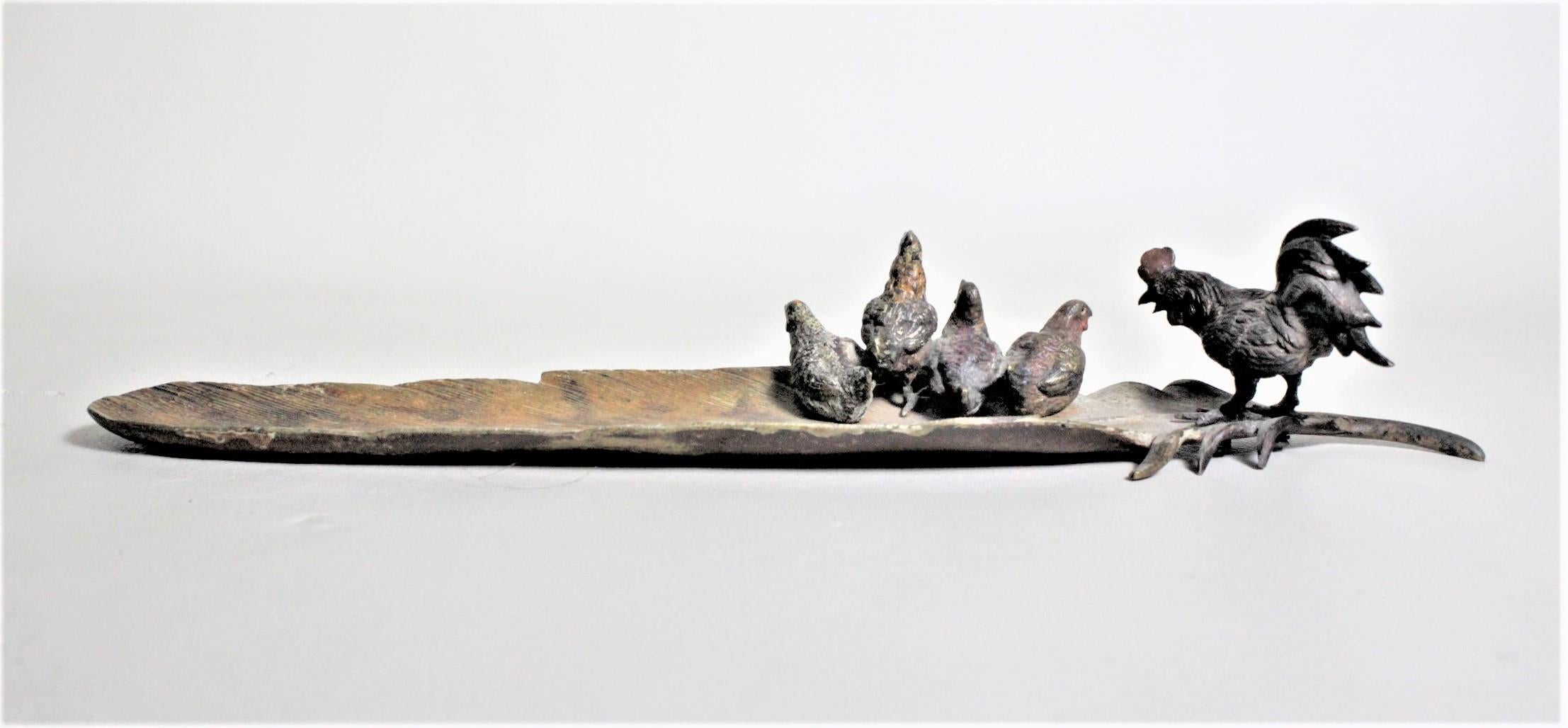 This antique cast and cold-painted bronze sculpture is unsigned but presumed to have been made in Austria in circa 1920. This well executed cast bronze study depicts several hens perched on a tobacco leaf and being overseen by a rooster. The casting