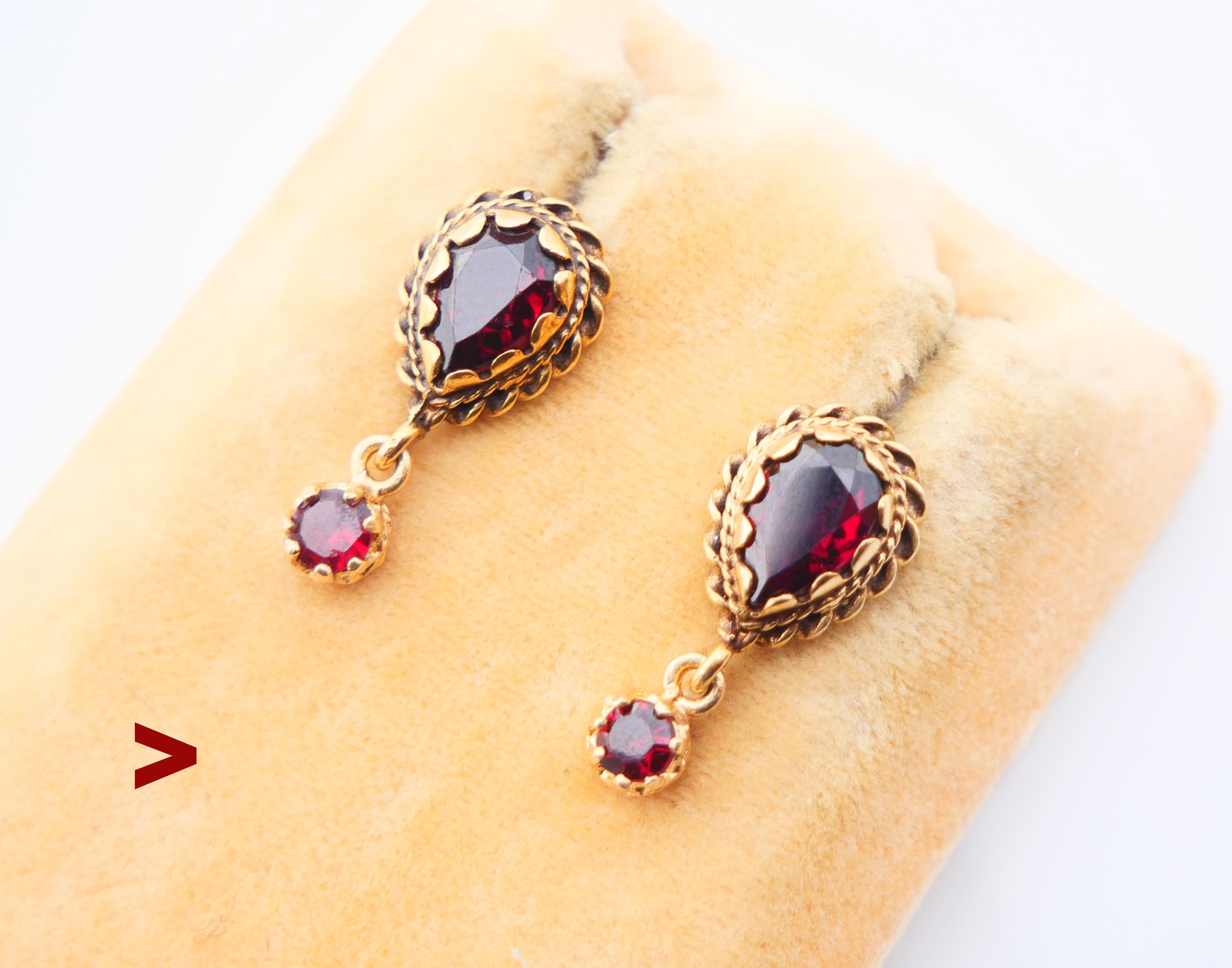 A pair of nice Austrian studs, hand - made ca. 1920s- 1930s in solid 14K Yellow Gold with freely suspended pendants decorated with natural Bohemian Garnets. 

No hallmarks on earrings, stoppers hallmarked 14K / metal tested solid 14K Yellow Gold.