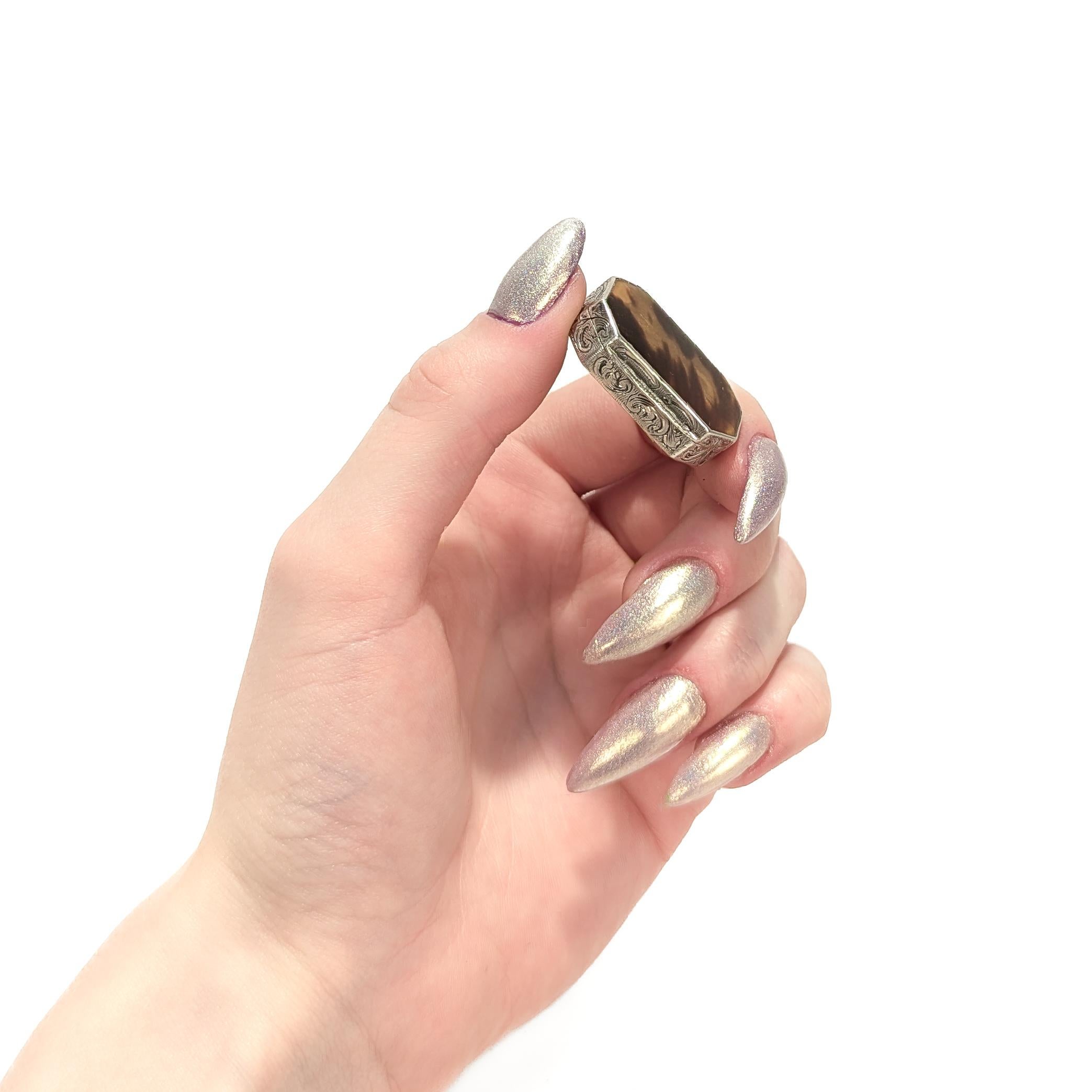A fine antique snuff or trinket box.

In .935 silver.

By Leo Wagner.

With engraved decoration throughout and the lid with a bezel-set cabochon of semi-translucent horn.

From the collection of the legendary interior decorator Mario Buatta.

Simply