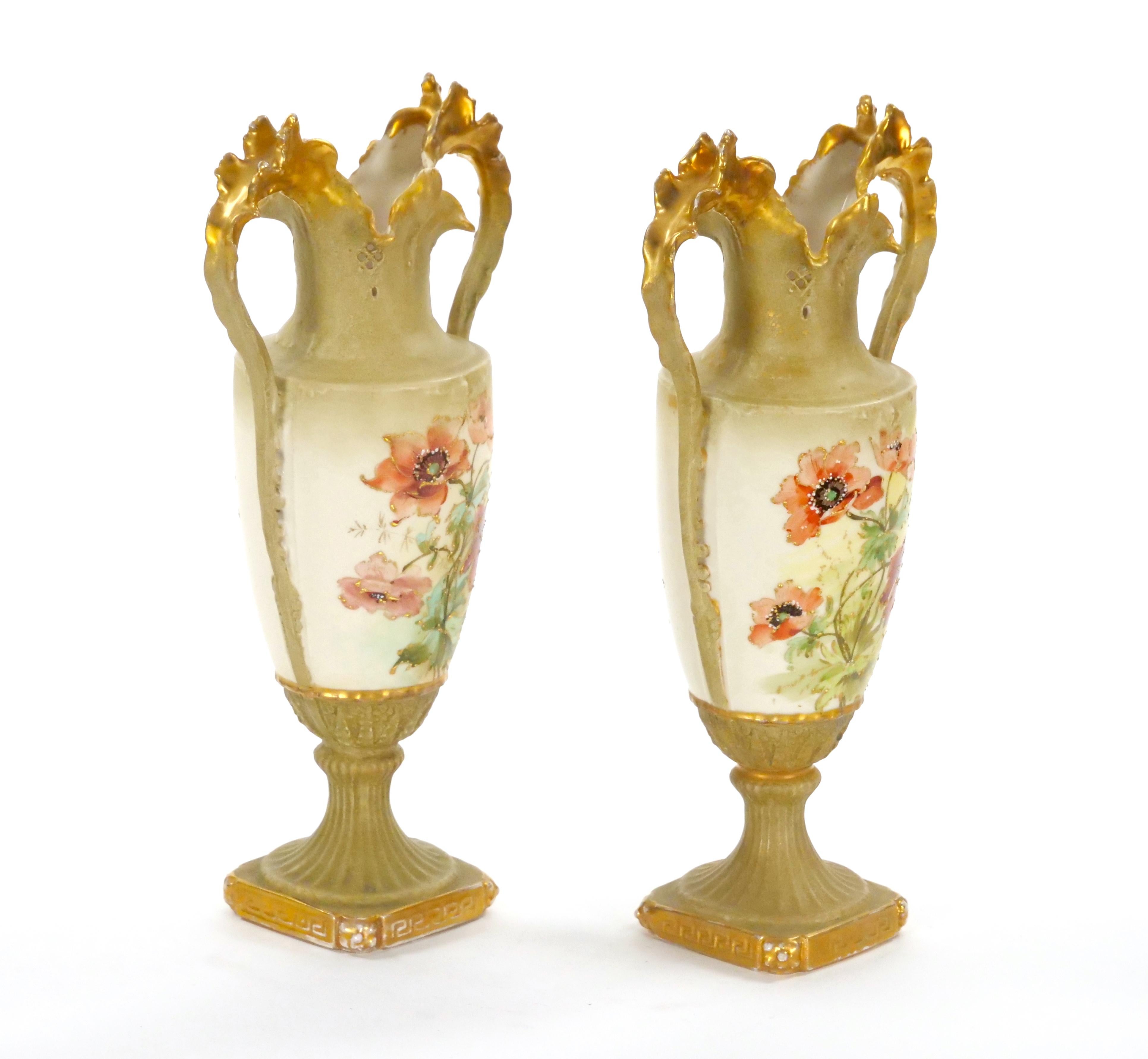 Ti presentiamo una squisita coppia di antichi vasi in porcellana austriaca, meticolosamente dipinti a mano e decorati in oro con motivi floreali e fogliati. Ogni vaso presenta un corpo a forma di urna ornato da vivaci dettagli floreali, completato