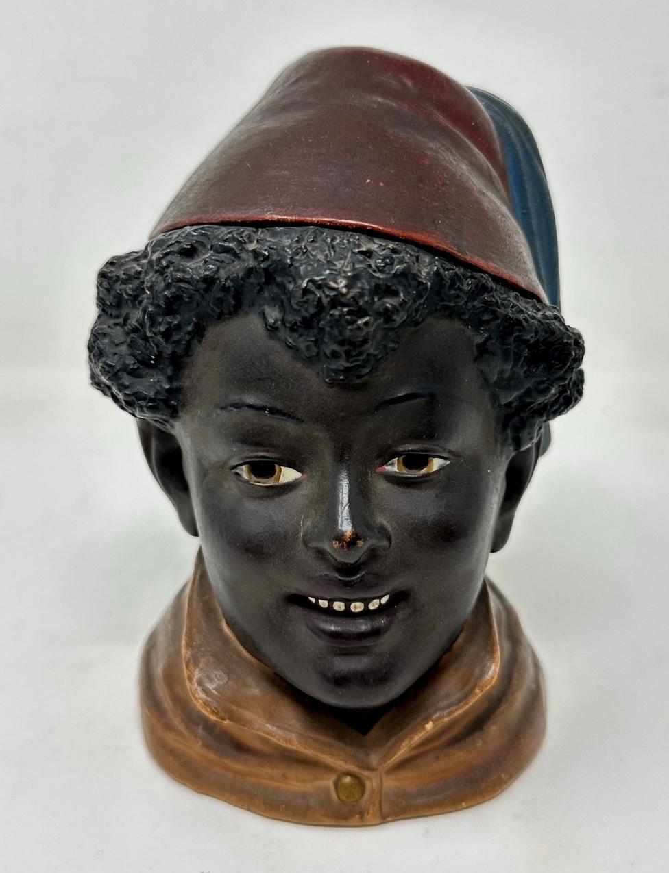 A Rare Example of an Austrian Hand Painted Terracotta Tobacco Jar, last quarter of the Nineteenth Century. 
The main body modelled as a North African Moroccan young boy wearing a tasseled felt style hat and a buttoned jacket. 

Condition: Superb for