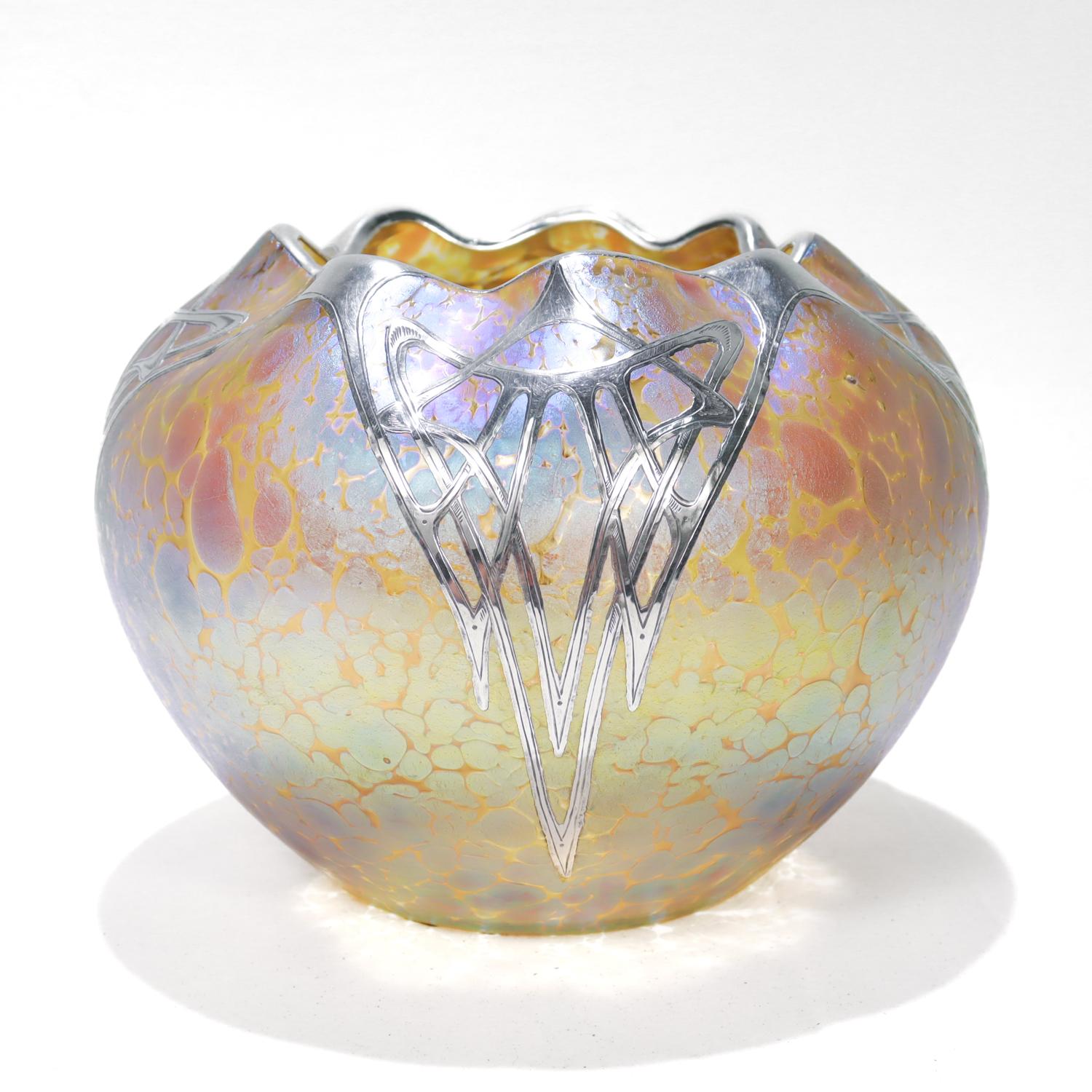 A fine antique Austrian art glass vase. 

By Loetz.

In clear glass with a Candia Papillon finish creating a silvery iridescent finish with brownish gold oil spots throughout.

With a scalloped rim and thick and silver overlay.

Simply a wonderful