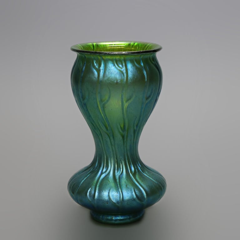 An antique Austrian vase by Loetz from the Neptune line offers green art glass construction with stylized seaweed in relief, unsigned, c1920

Measures - 7.25'' H x 4'' W x 4'' D.

Catalogue Note: Ask about DISCOUNTED DELIVERY RATES available to most
