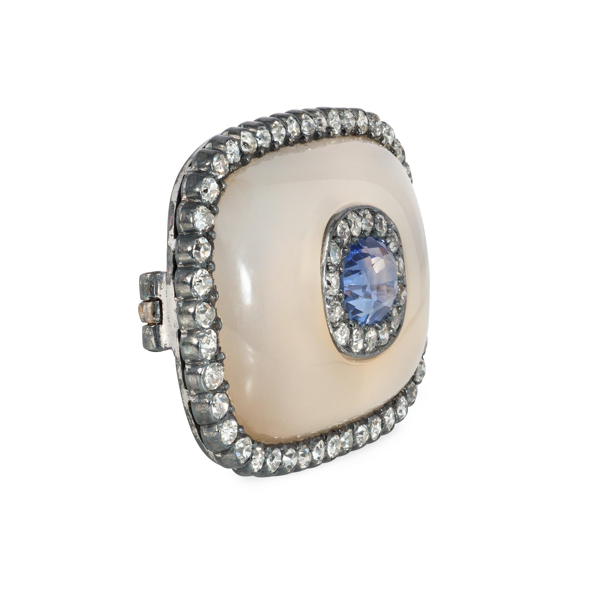 An antique sapphire, diamond, and chalcedony brooch of rounded rectangular form, centered by an oval Ceylon sapphire in a diamond surround, further set within a piece of carved chalcedony with a diamond border, in silver-topped gold.  Austria.  Atw