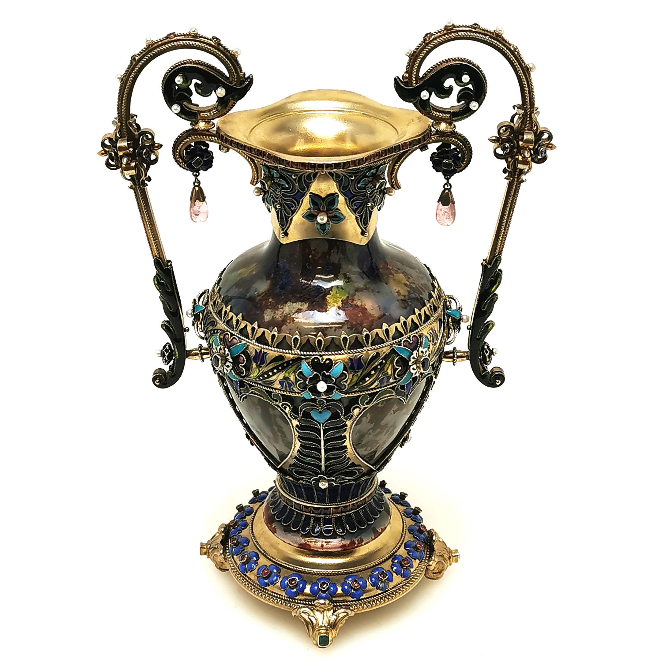 A spectacular Antique Austrian silver gilt and enamel vase ornamented with a variety of polished gems. The body of the Vase is embellished with Bohemian style enamelled patterning while the scrolls and borders of the Vase are further decorated with