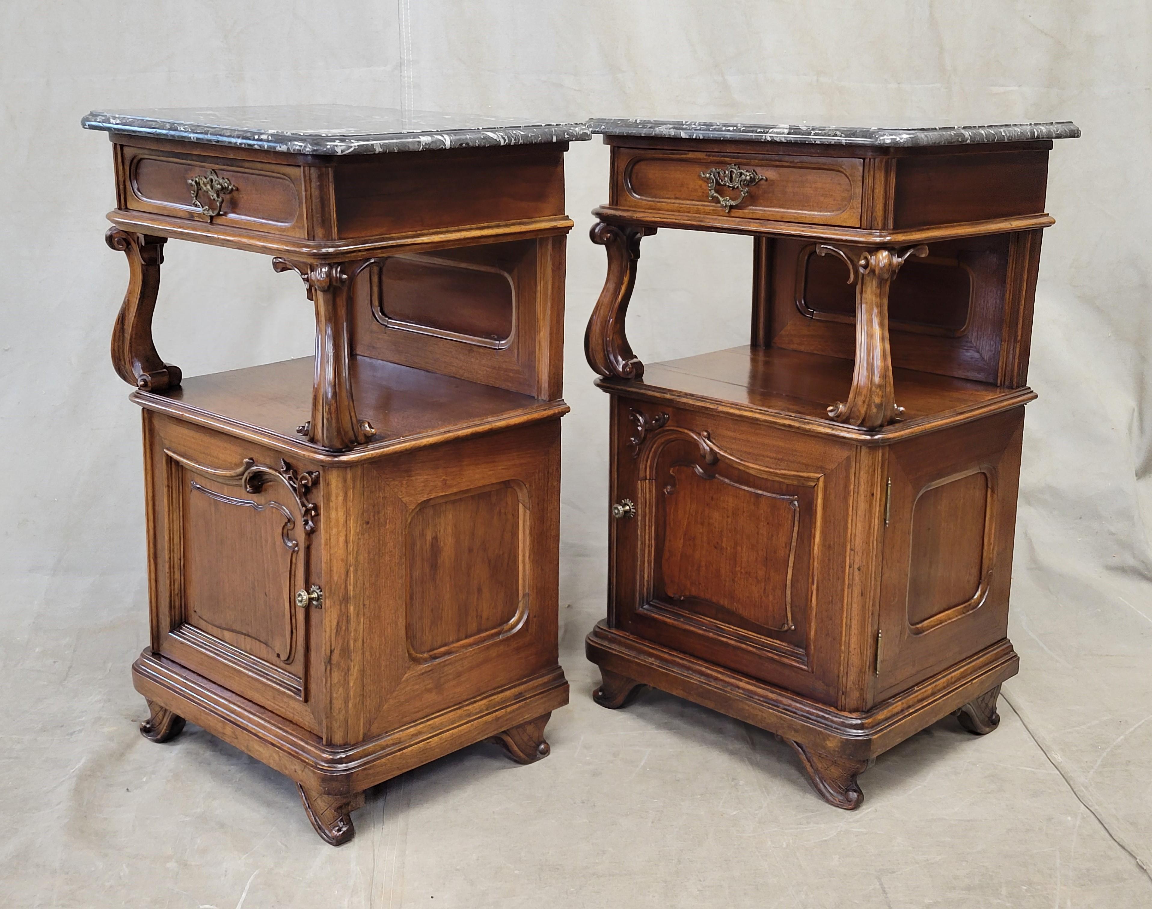 A gorgeous pair of high-end, antique Austrian art nouveau walnut nightstands / pot cupboards with original black marble tops. Note the stunning curvilinear accents on the feet, door panel, top supports, and even the drawer pulls. Brass drawer pulls