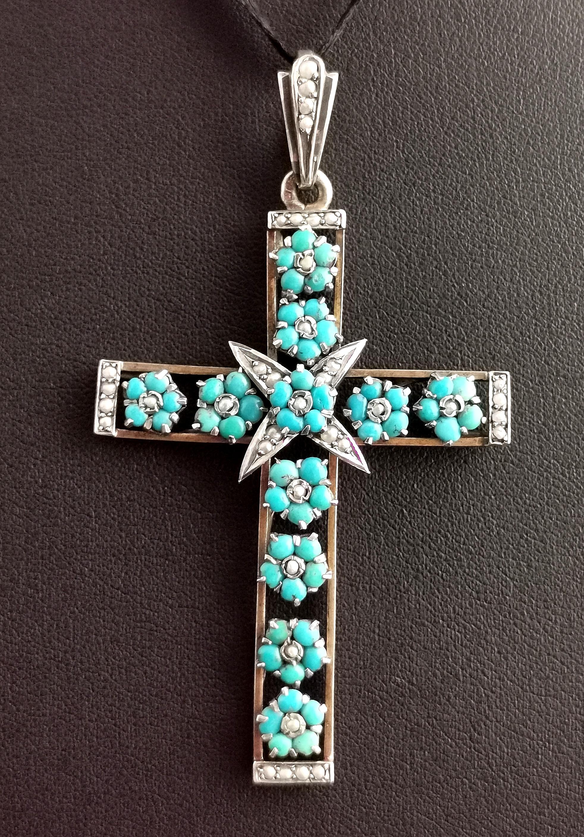 An exceptionally beautiful Victorian era Austro-Hungarian Cross pendant.

It is a large openwork design cross adorned with tiny turquoise forget me not flowers, each flower consisting of five turquoise cabochons and a tiny seed pearl to the