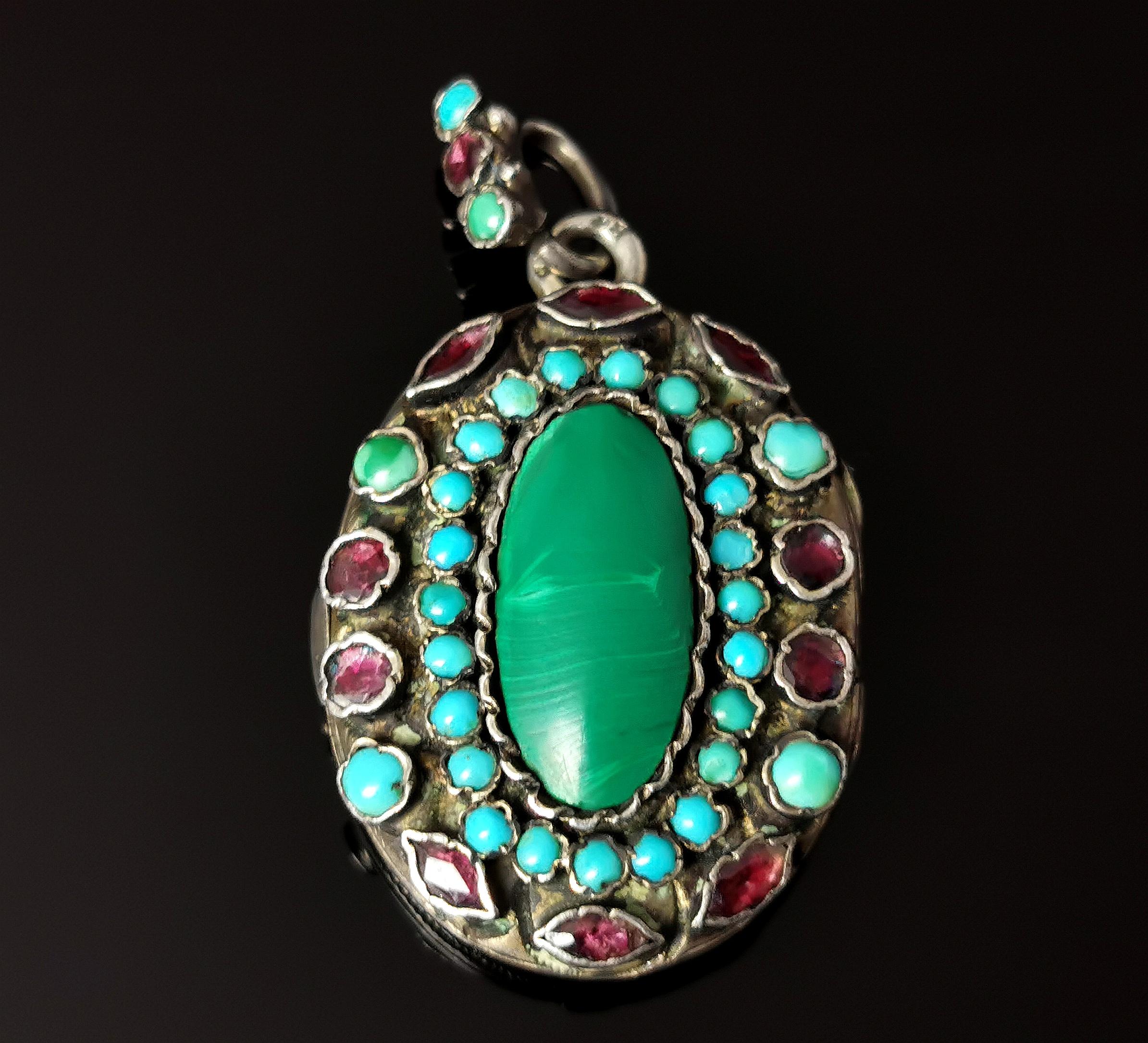 A gorgeous and unusual antique Austro-Hungarian locket pendant.

Reminiscent of the renaissance revival styles this locket is heavily gem set to the front, gems include Garnet, Turquoise and malachite.

The garnets are almandine garnets adorning the