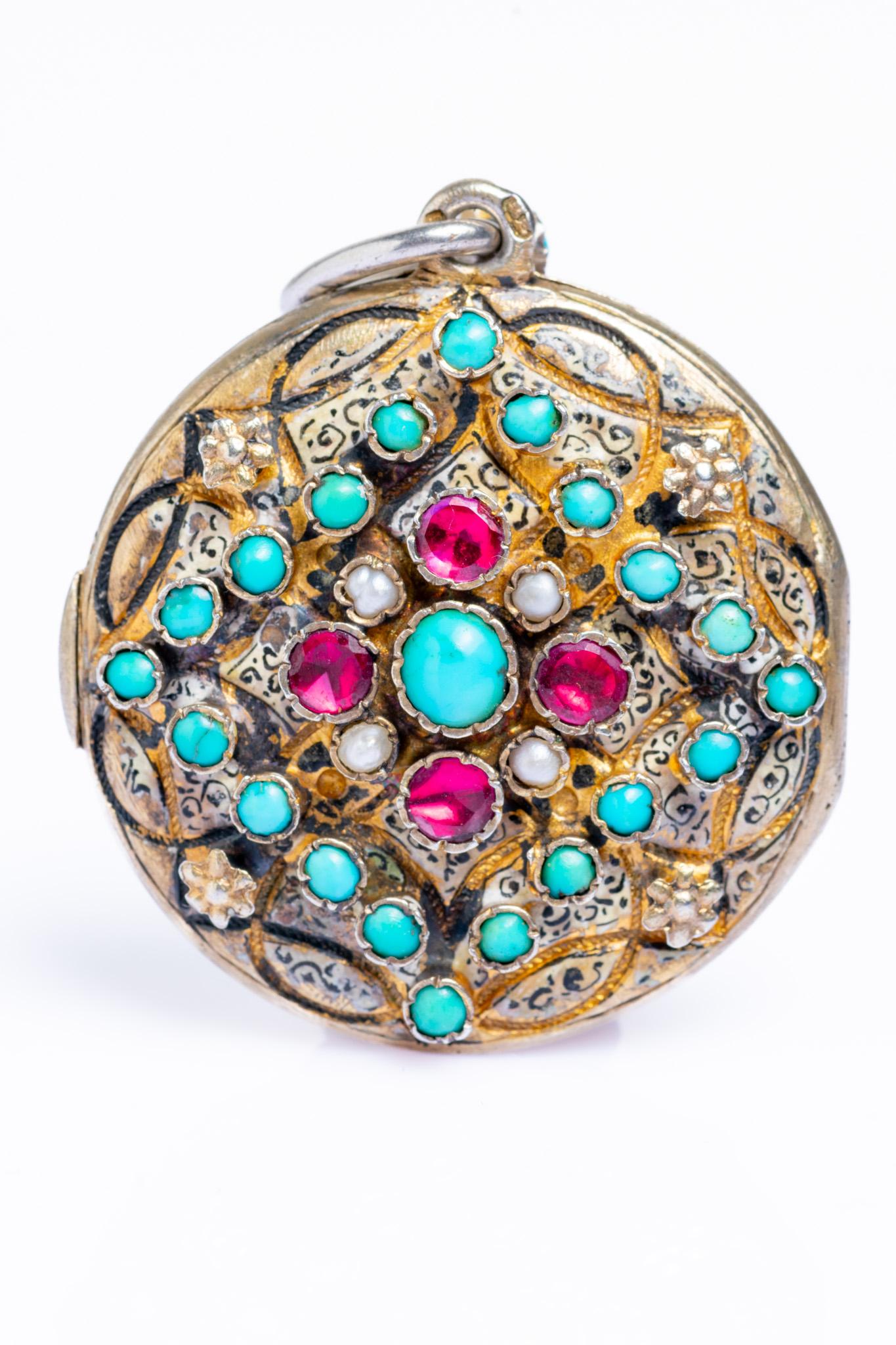 This exquisite late 19th century Austro-Hungarian turquoise, garnet and pearl circular locket pendant is dated circa 1890. The locket is decorated with a central turquoise cabochon surrounded by four garnets, four half freshwater pearls and