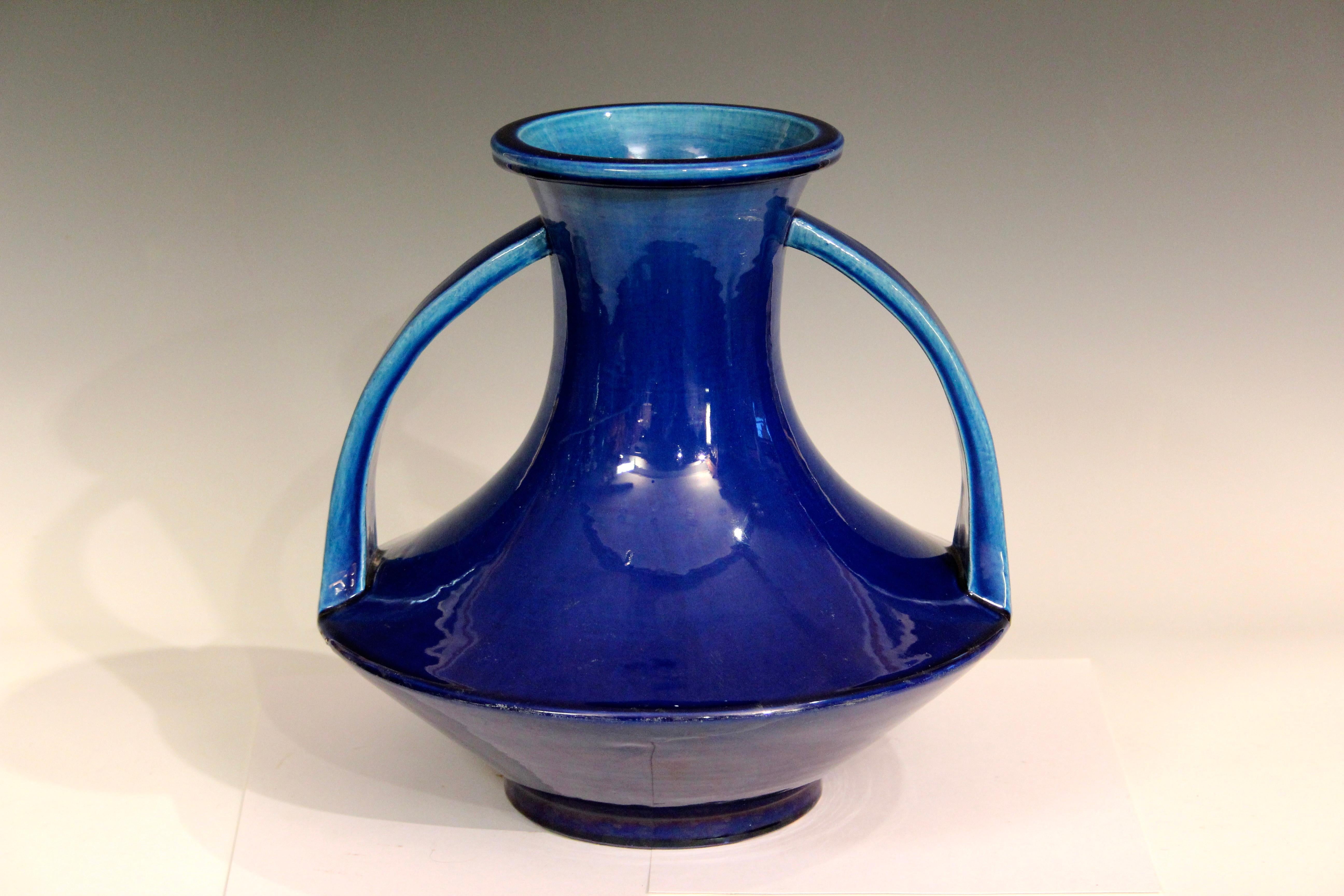 Vase ancien en poterie d'Awaji à glaçure bleu turquoise profond, vers les années 1920. Magnifique mouvement avec de grandes poignées de sangle appliquées qui décrivent un cercle avec la base reflétant la forme circulaire de la circonférence. 12