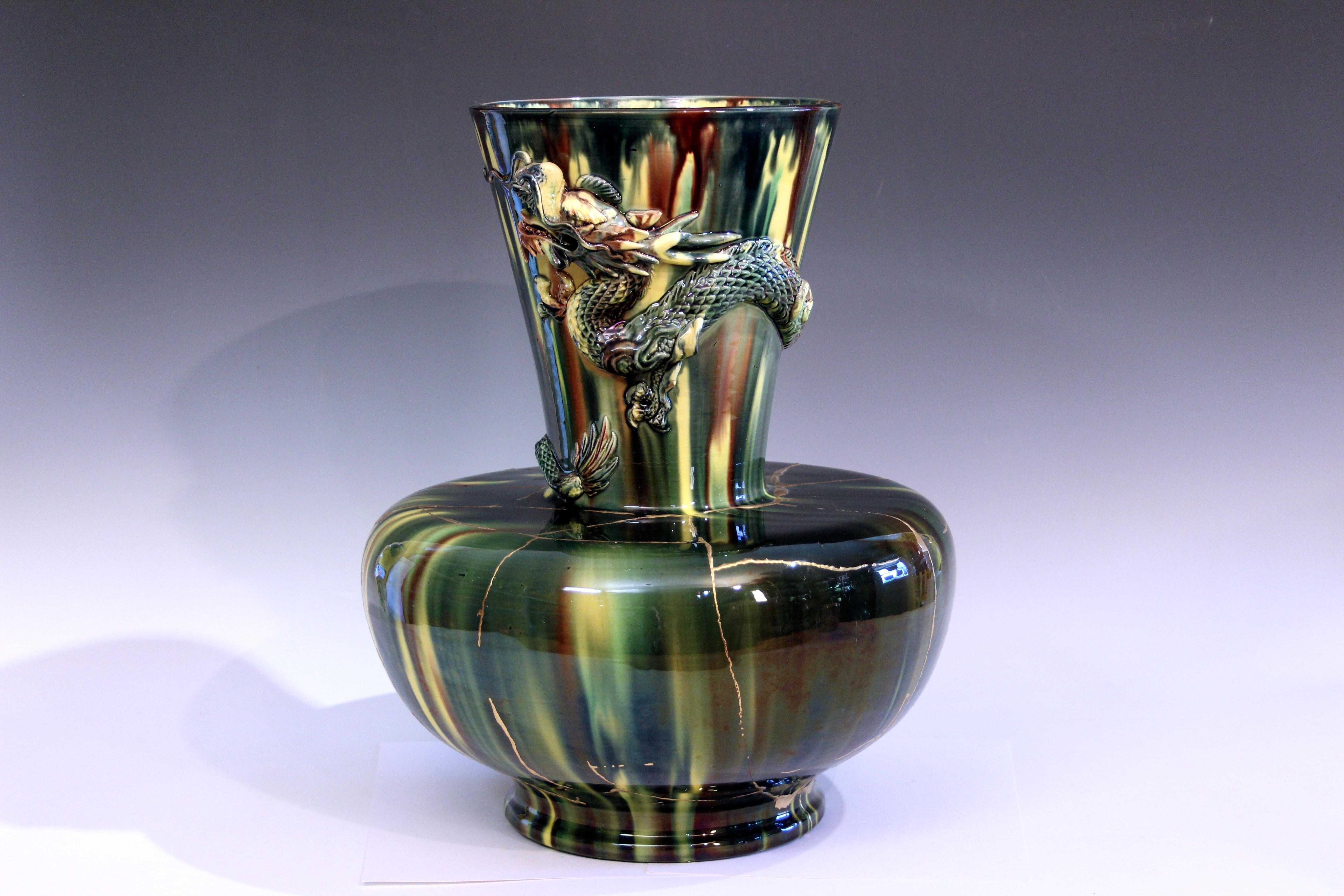 Grande vaso a forma di drago di Awaji Pottery dalla forma insolita e drammatica con smalto giallo flambe. Circa anni '20. Il drago si arriccia intorno al collo ampio e svasato del vaso. Il corpo del vaso è stato riparato con il Kintsugi, l'arte