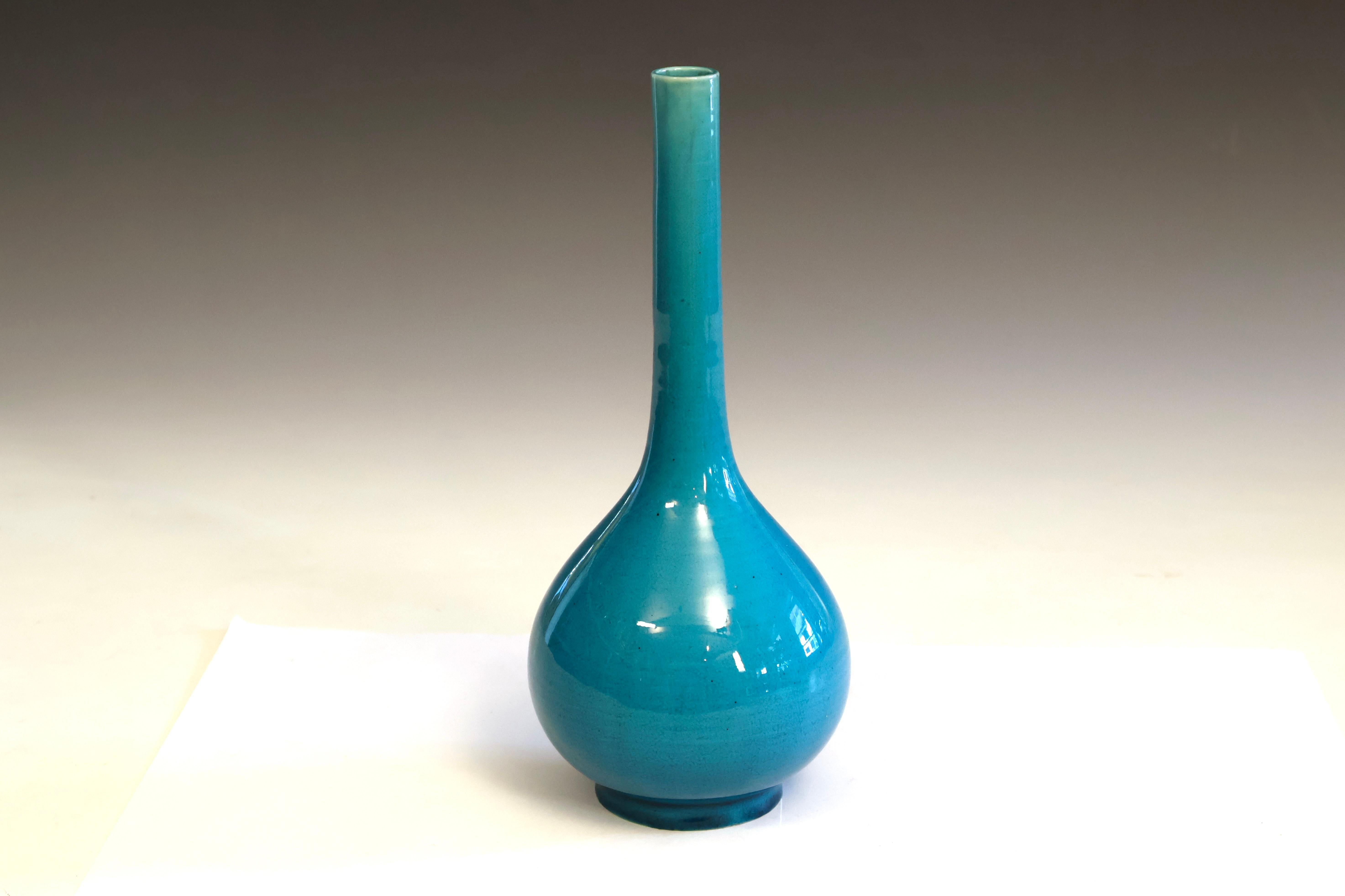 Antiguo jarrón botella de cerámica japonesa Awaji con un llamativo esmalte craquelado turquesa y un elegante cuello alargado con un cuerpo redondeado y bulboso que se estrecha hasta un pequeño pie circular. Torneado a mano, hacia 1910. El acabado