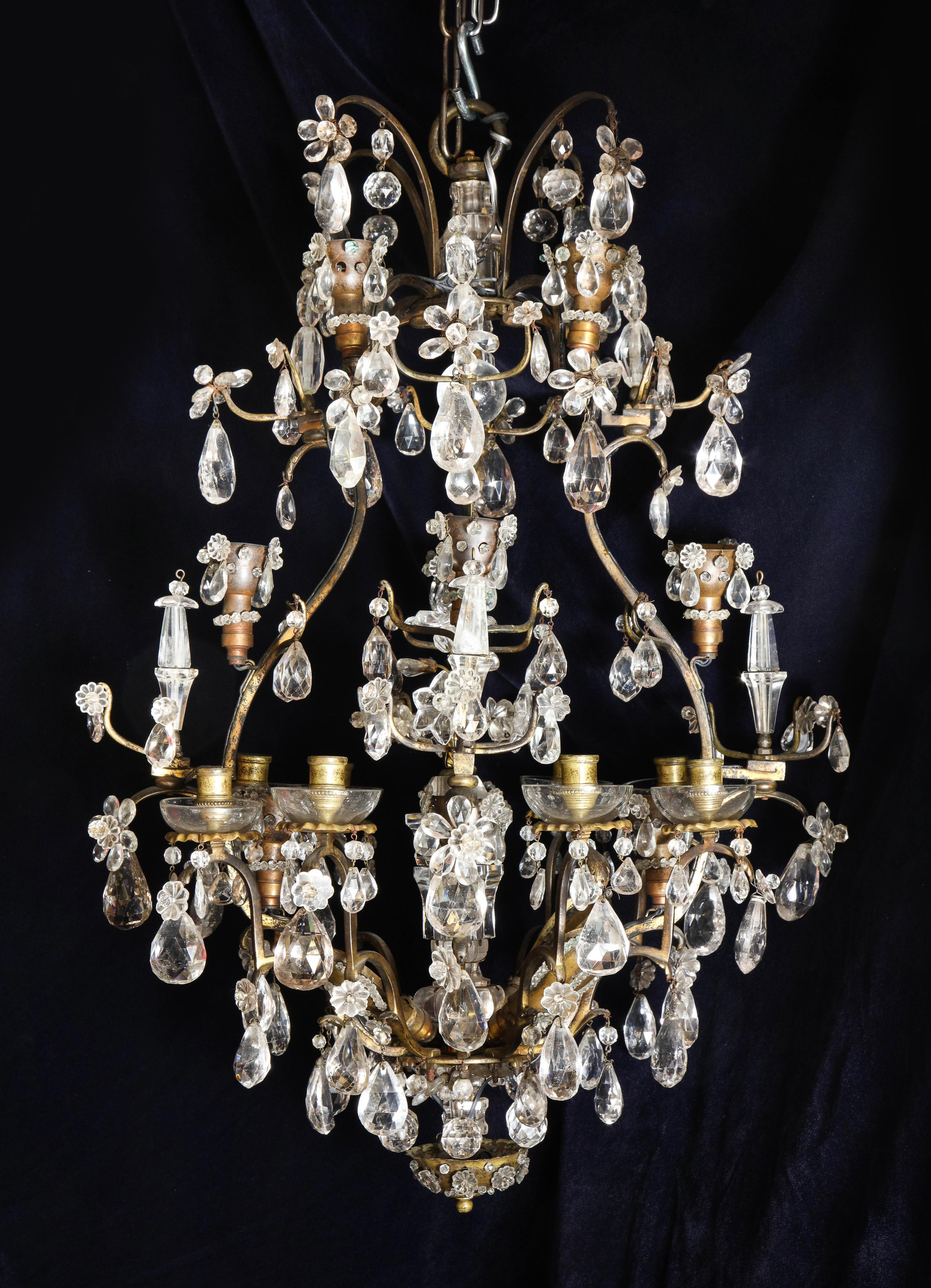 Un superbe lustre ancien Baguès français Louis XVI en bronze doré et cristal de roche taillé en forme de cage, avec plusieurs lumières, d'un artisanat exquis, embelli de fleurs en cristal de roche taillé, de prismes et orné d'un ornement floral en