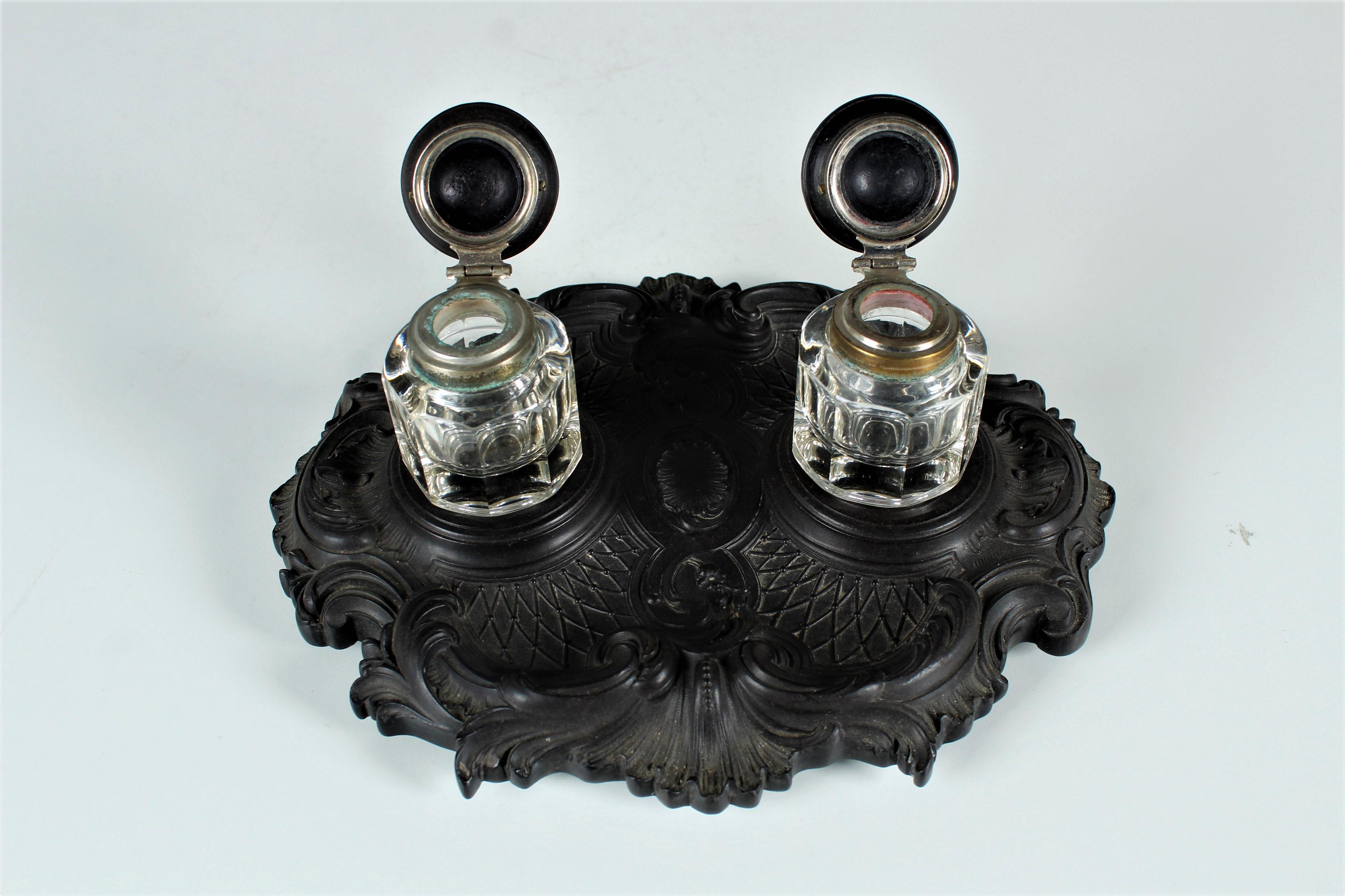 Beautiful antique inkstand with two crystal inkwells.
The base and the lids are made of gutta-percha, a molded resin, France, circa 1880.
The lids feature brass hinged collars.
A classic design covers the flat base.
Similar inkwells can be found in