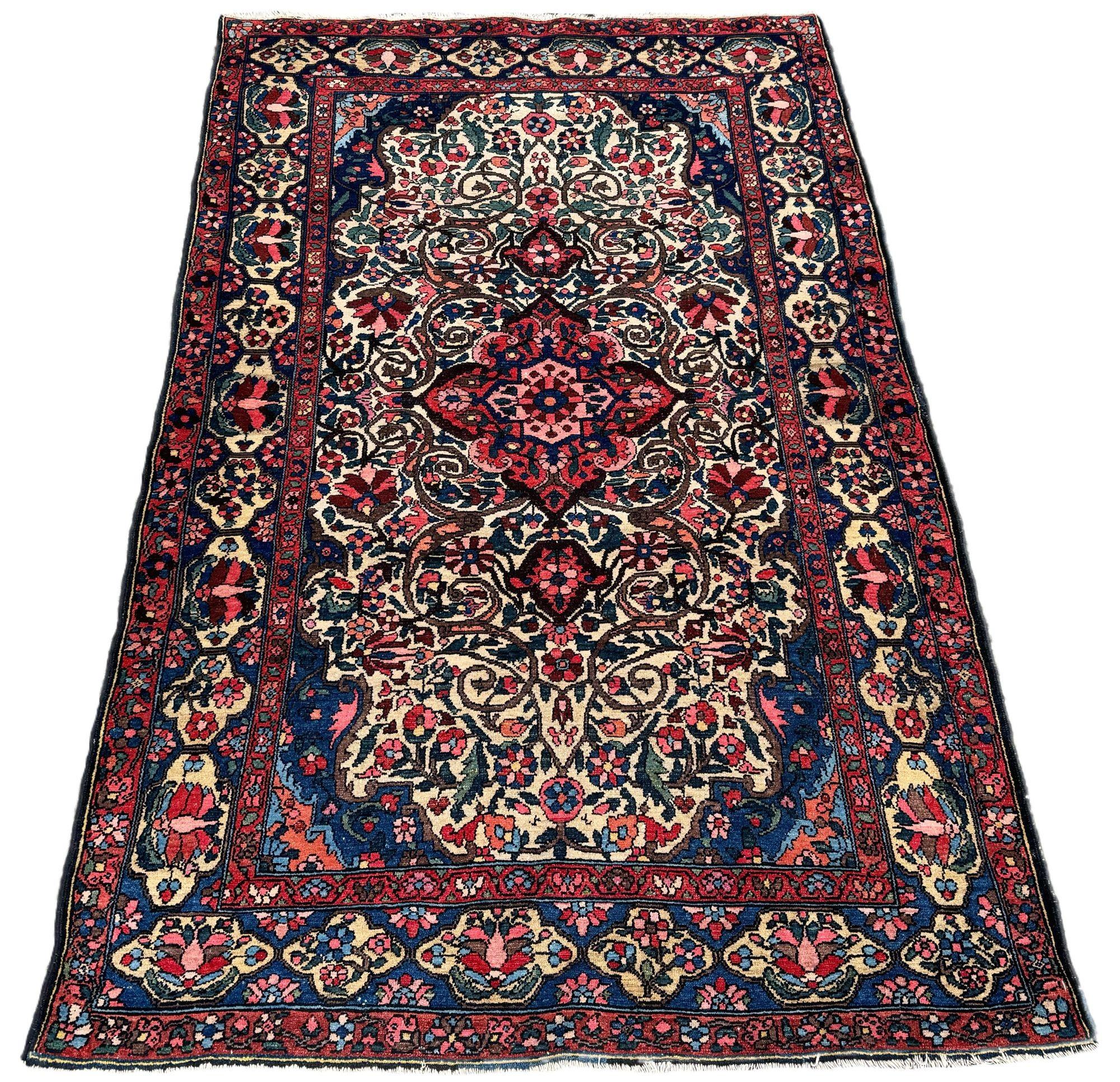Un fabuleux tapis ancien de Bakhtiar, tissé vers 1920. Le motif présente un petit médaillon en terre cuite sur un champ ivoire inhabituel de têtes de fleurs et de feuilles reliées par des arabesques en volutes. Finement tissé avec de jolies couleurs