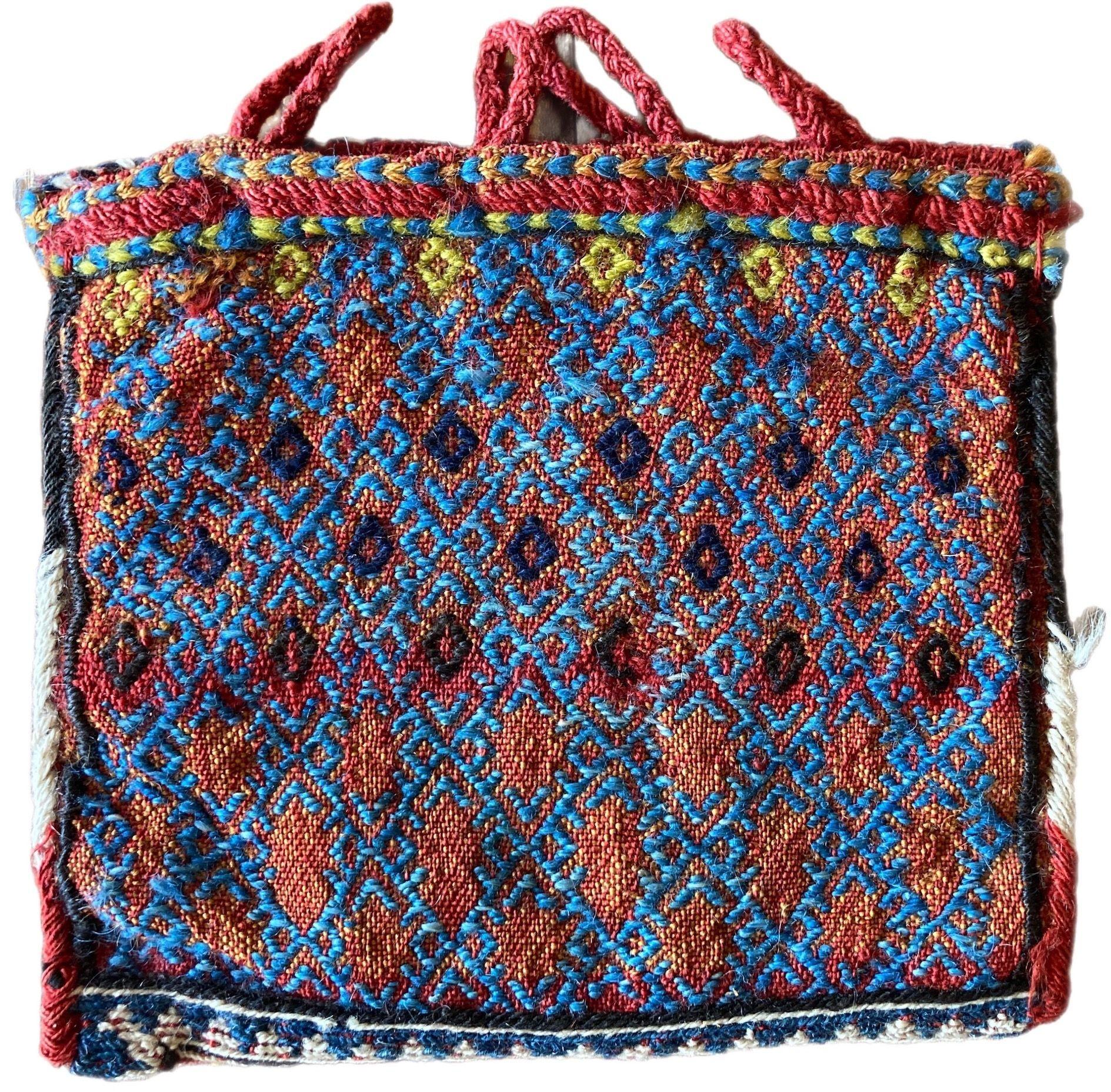 A lovely antique Chanteh woven by the nomadic Bakhtiari tribe circa 1880 with a Soumakh weave on both sides. The design features an allover lattice in golds and reds on one side and blues and reds on the other. These small vanity bags were woven by