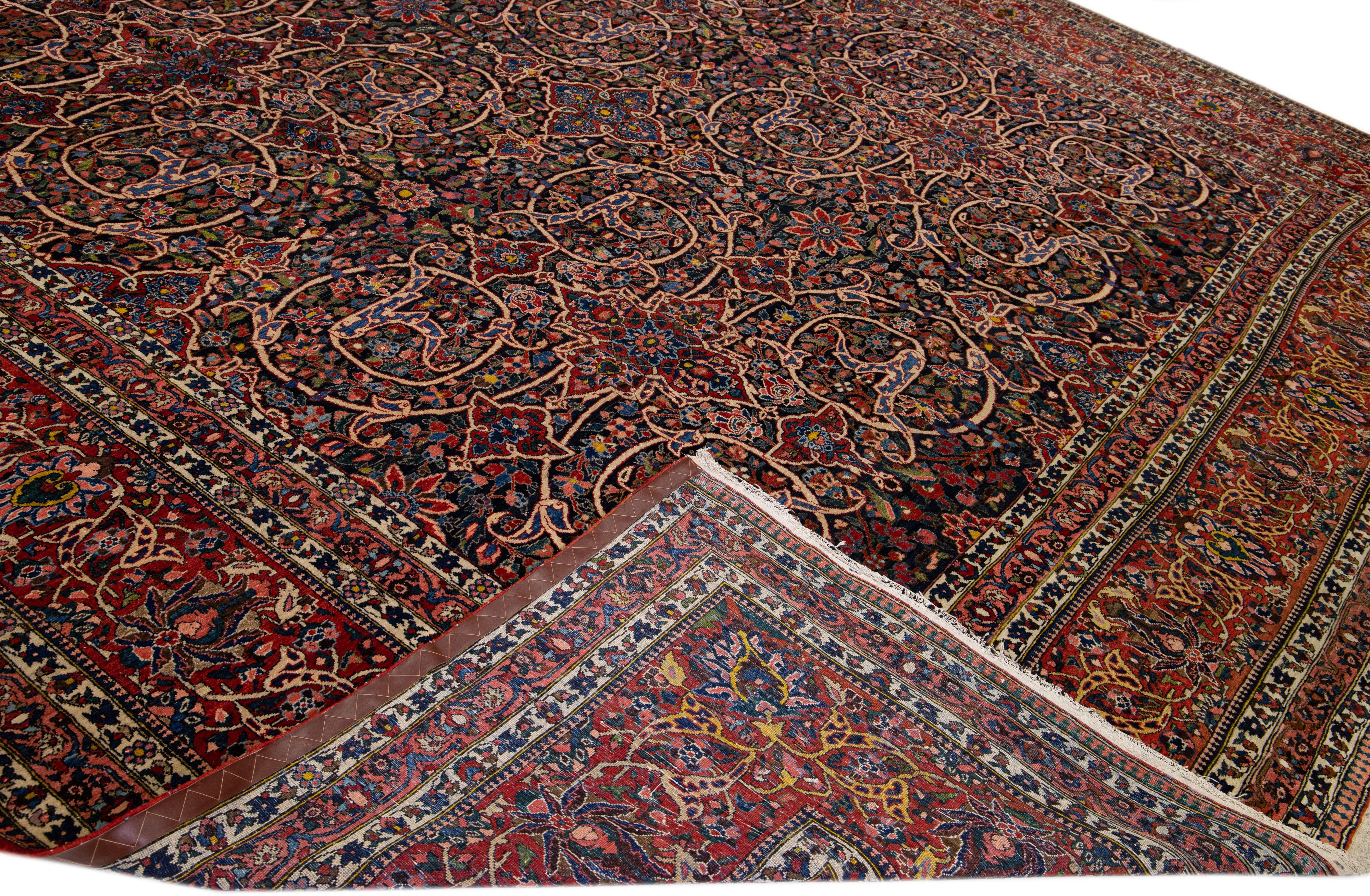 Beautiful antique Bakhtiari hand-knotted wool rug with a dark blue field. This piece has a red-designed frame with multicolor accents on a gorgeous all-over classic floral pattern design.

This rug measures 14'3