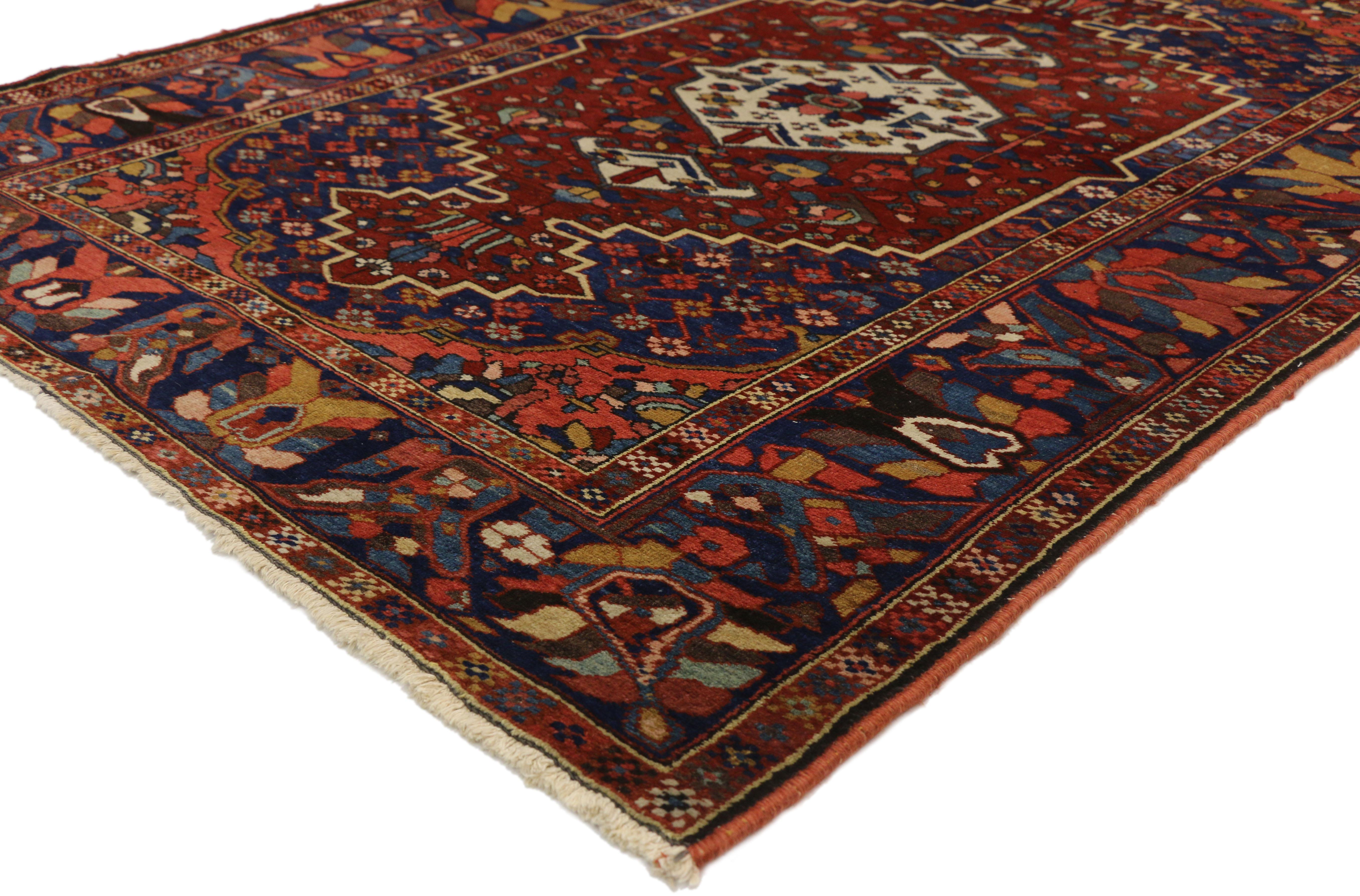 Featuring highly desirable colors and a traditional modern style, this antique Bakhtiari Persian rug embodies a harmonious energy captivating attention with its many layers and impeccable hand-knotted wool. Vibrant geometric florals and the oxblood