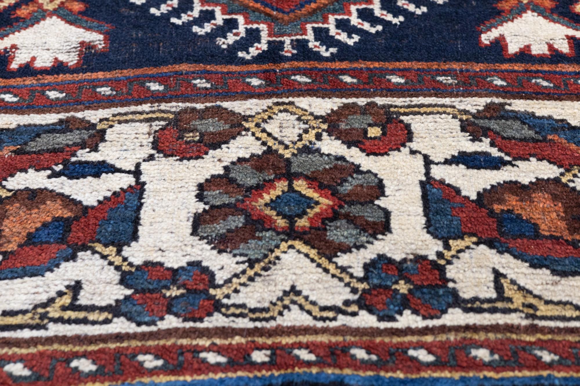 Antiker Bakhtiari Teppich 5'3'' x 10'1''.  Das marineblaue Feld zeigt ein aufwändig gehaktes Stangenmedaillon aus drei Sechsecken in Rot und abgewischtem Hell-/Mittelblau sowie kühn zurückgeschlagene Volutenenden. Schlanke Stiele verbinden die