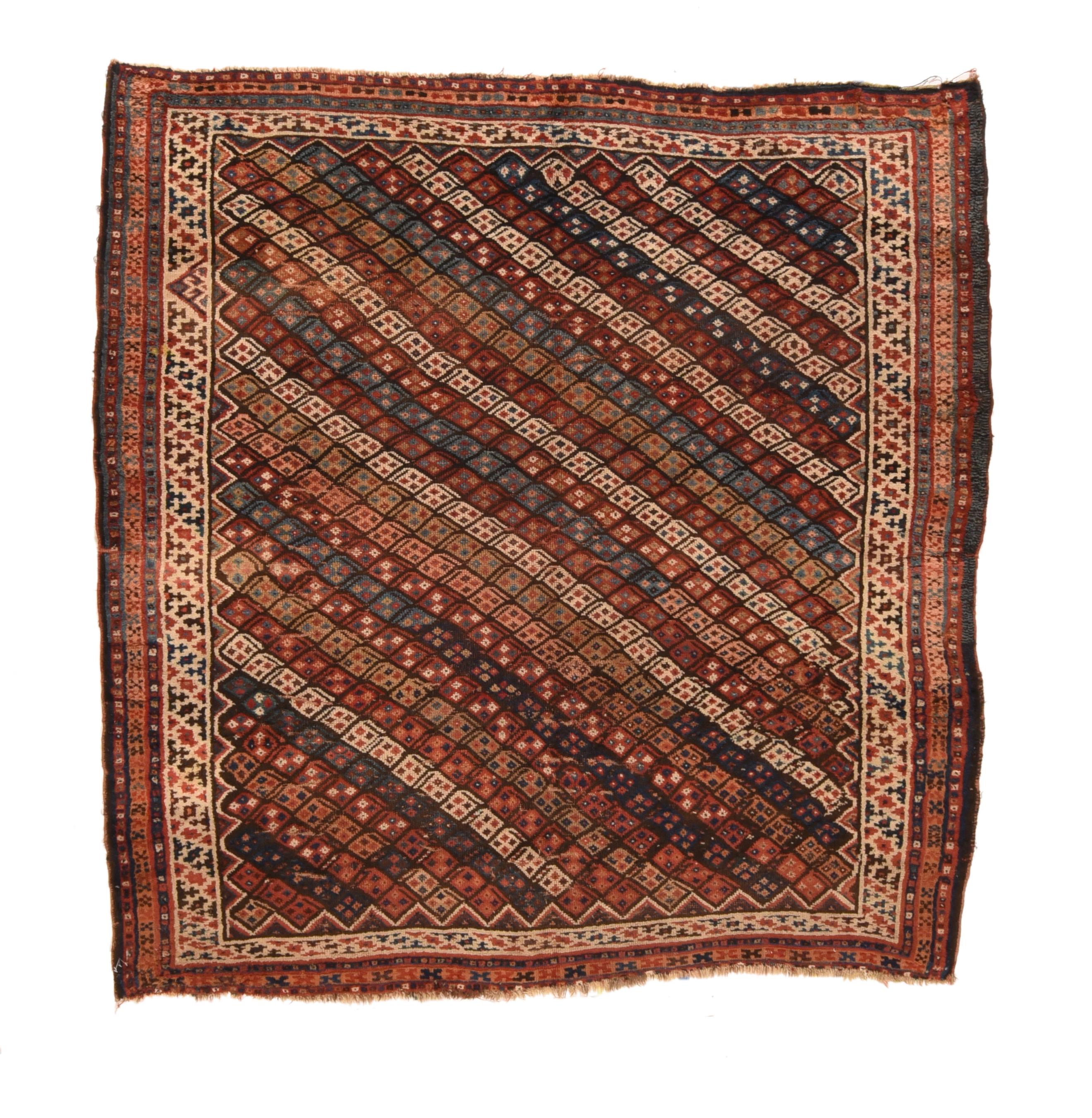 Alfombra antigua Bakhtiari 6'6'' x 6'7''. Tejido tribal persa occidental, con un dibujo boteh de rayas de colores diagonales sobre azul más oscuro. Borde estrecho con un marco mayor de fondo marfil que muestra diagonales de colores rotos. Reducción
