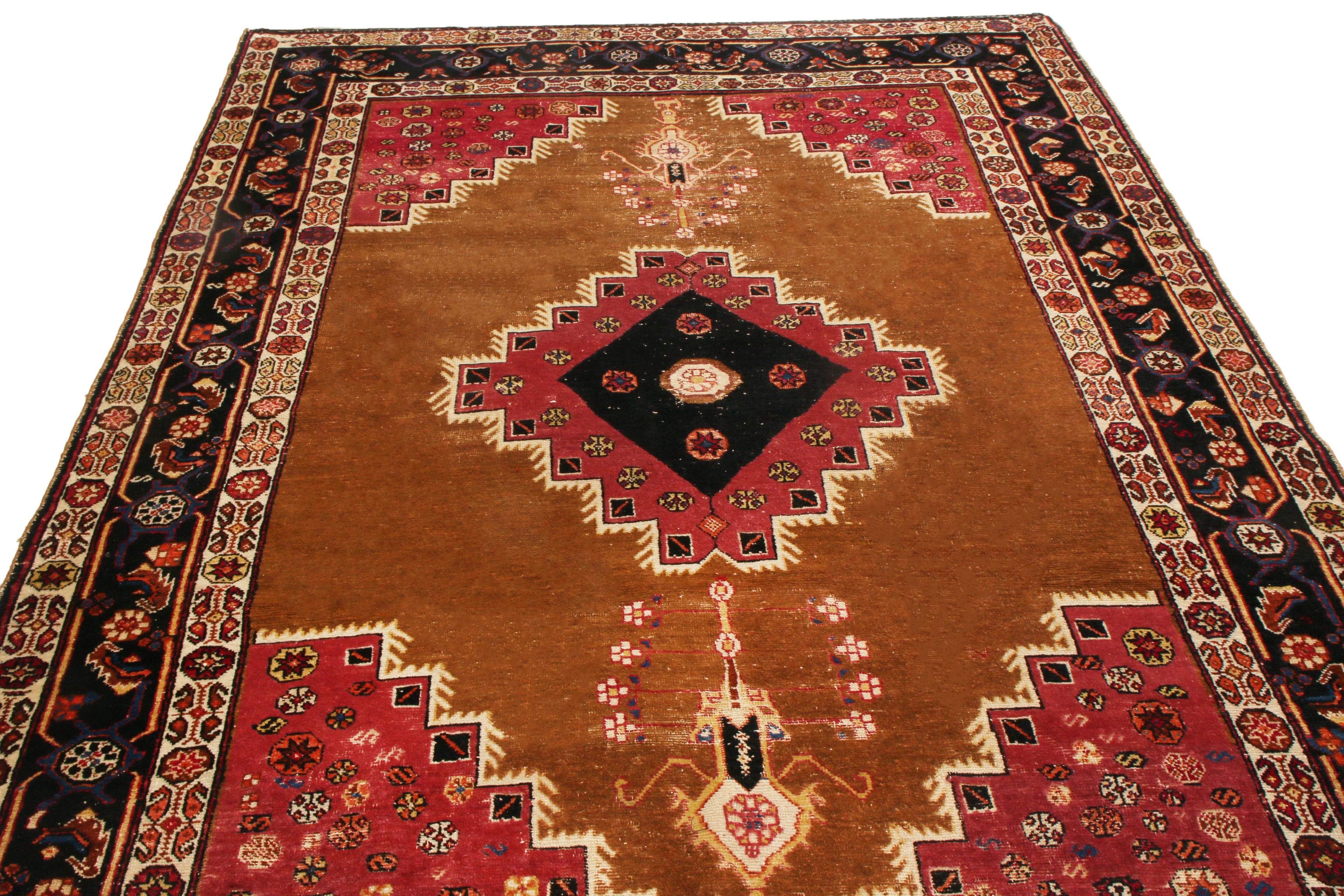 Originating from Persia in 1900, this antique transitional Bakhtiari rug hosts uncommon regal colorways with a varied series of spiritual symbols. Hand knotted in durable, quality wool, the black and maroon red medallions are emboldened against a