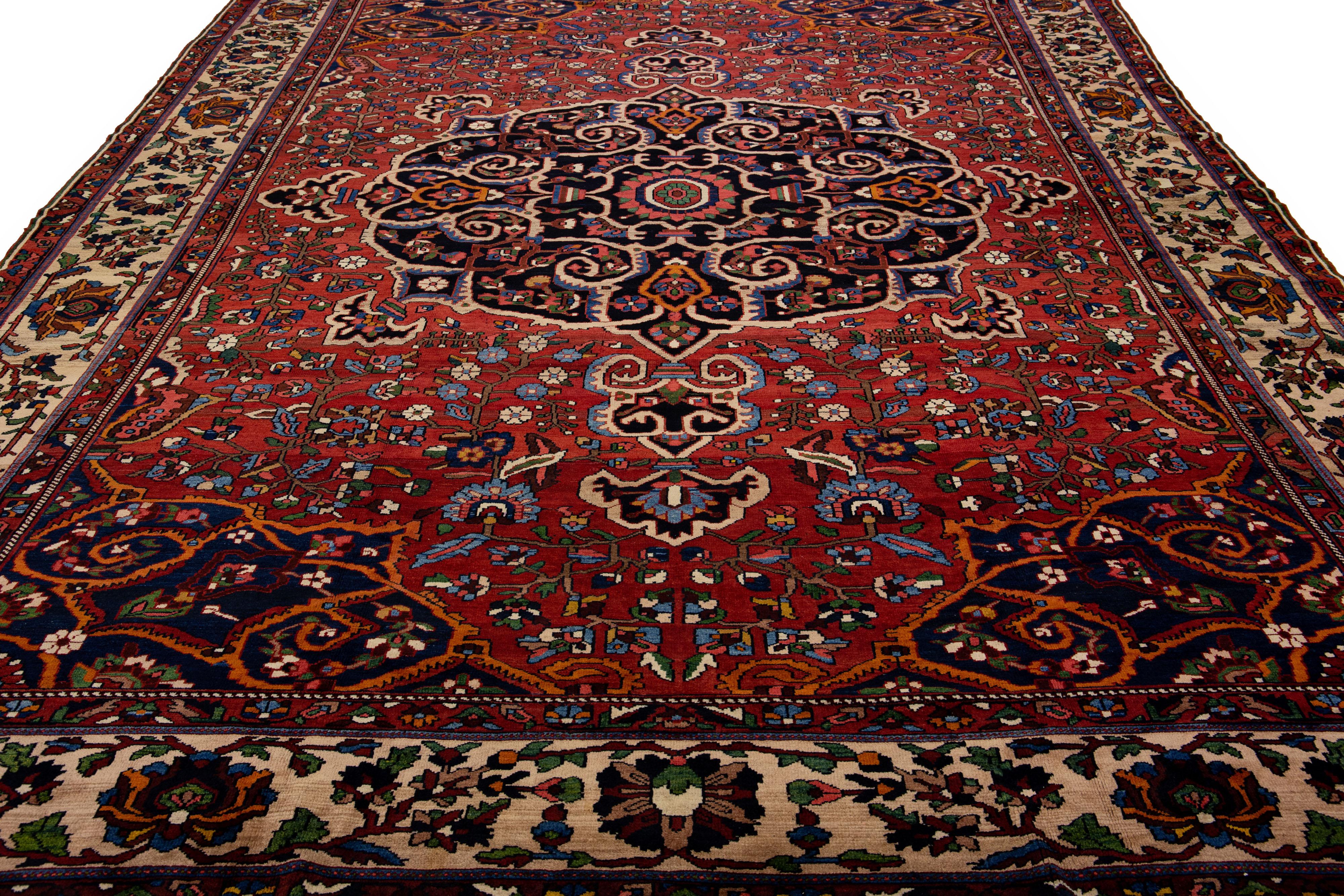 Beautiful Antique Bakhtiari hand-knotted wool rug with a red field. This Persian piece has an all-over multicolor accent in a gorgeous classic Medallion motif.

This rug measures 11'4