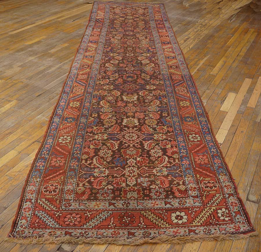 The somewhat corroded dark brown field of this wide Persian format kenare (runner) shows a Herati all-over design in low relief which is detailed in cream, sand, red and navy. The pattern has a strong, long centrality with plenty of enlivening light