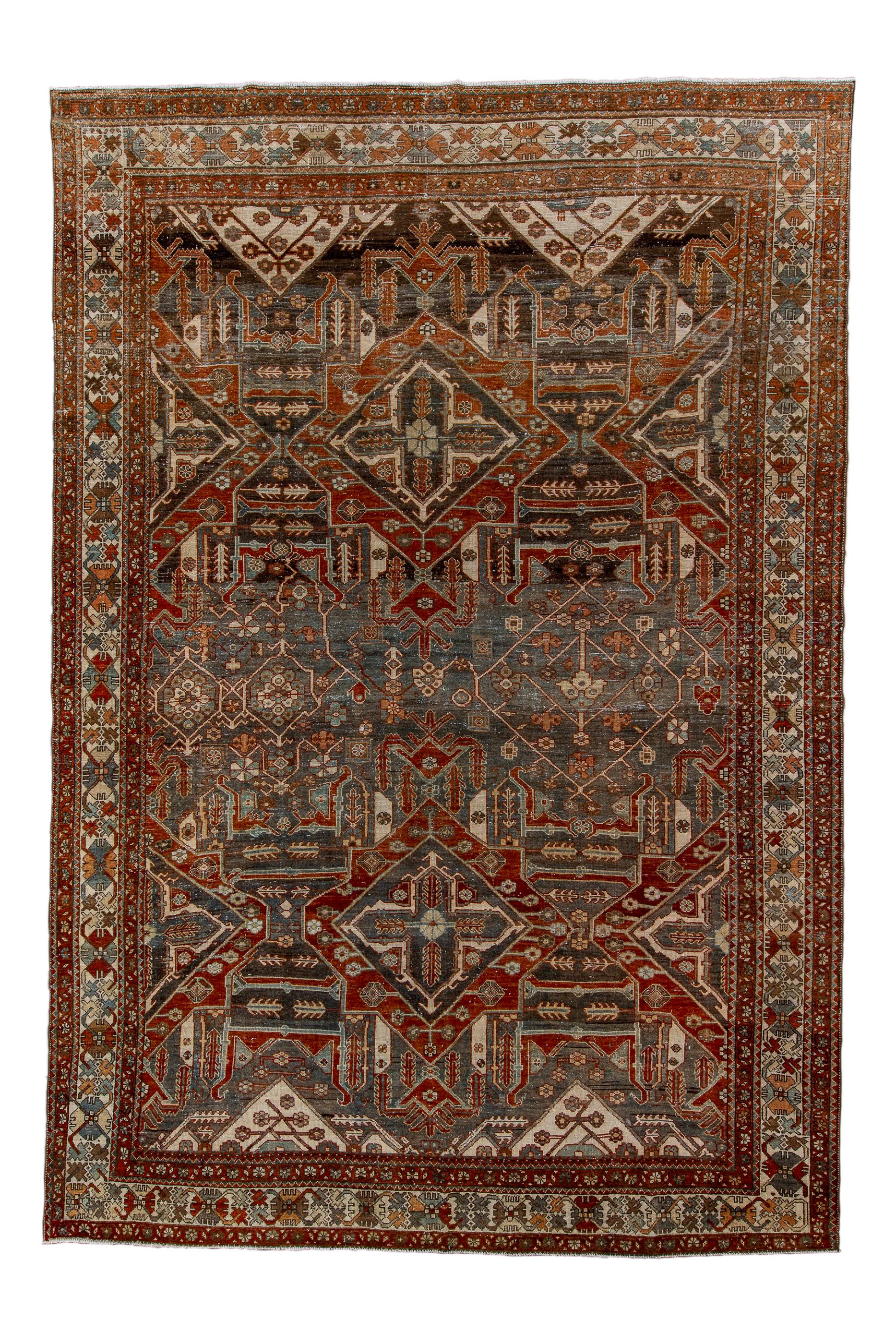 This village roomsize carpet shows a large allover pattern marked with two rows of characteristic Baktiary octogrammes each enclosing a pointed cross with four interior radiating palmettes.  Strongly abrashed dark slate field.  Ecru triangles above