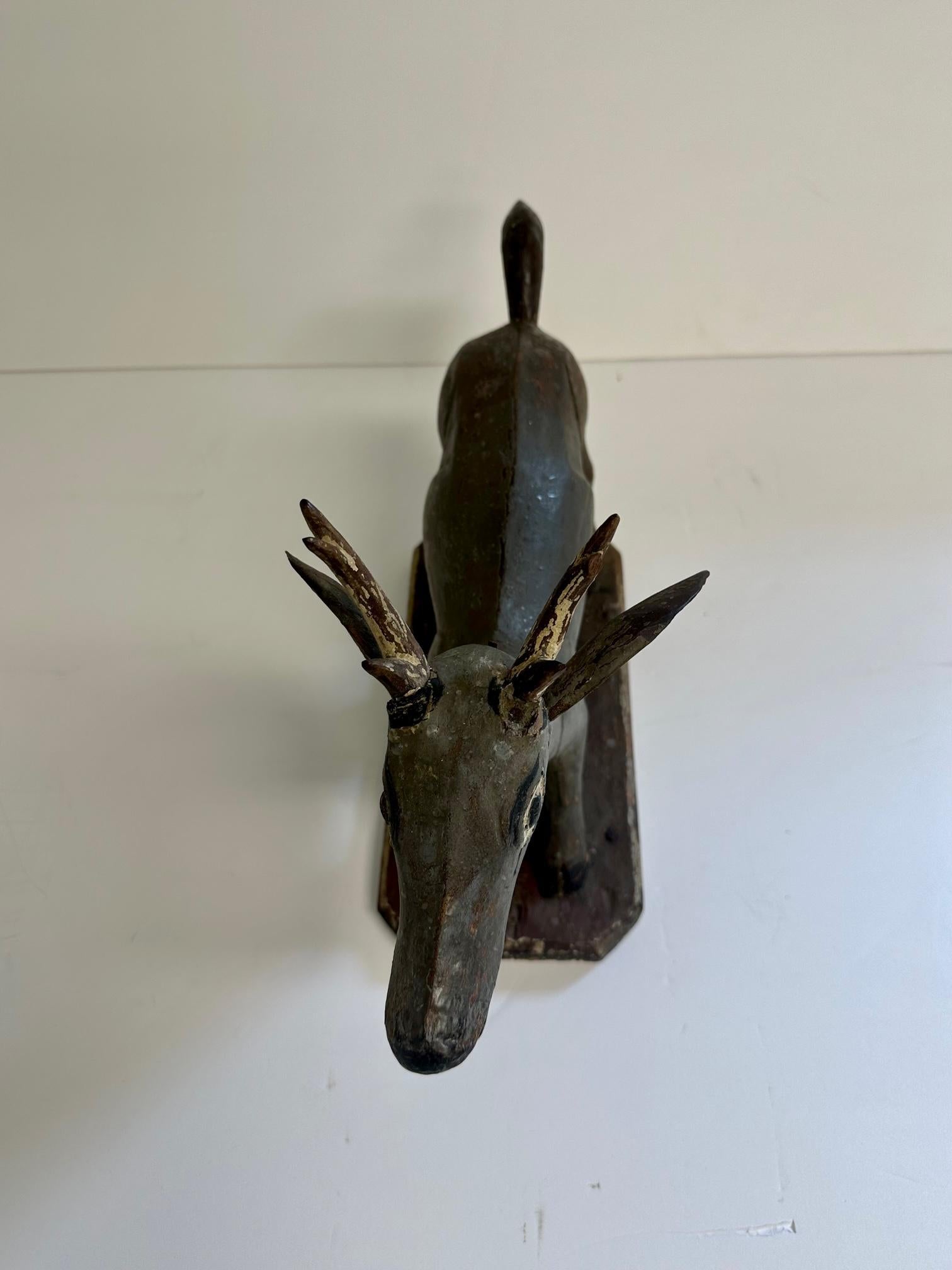 Whimsical hand carved Balinese sculpture of a stylized deer having original paint decoration and wonderful character.