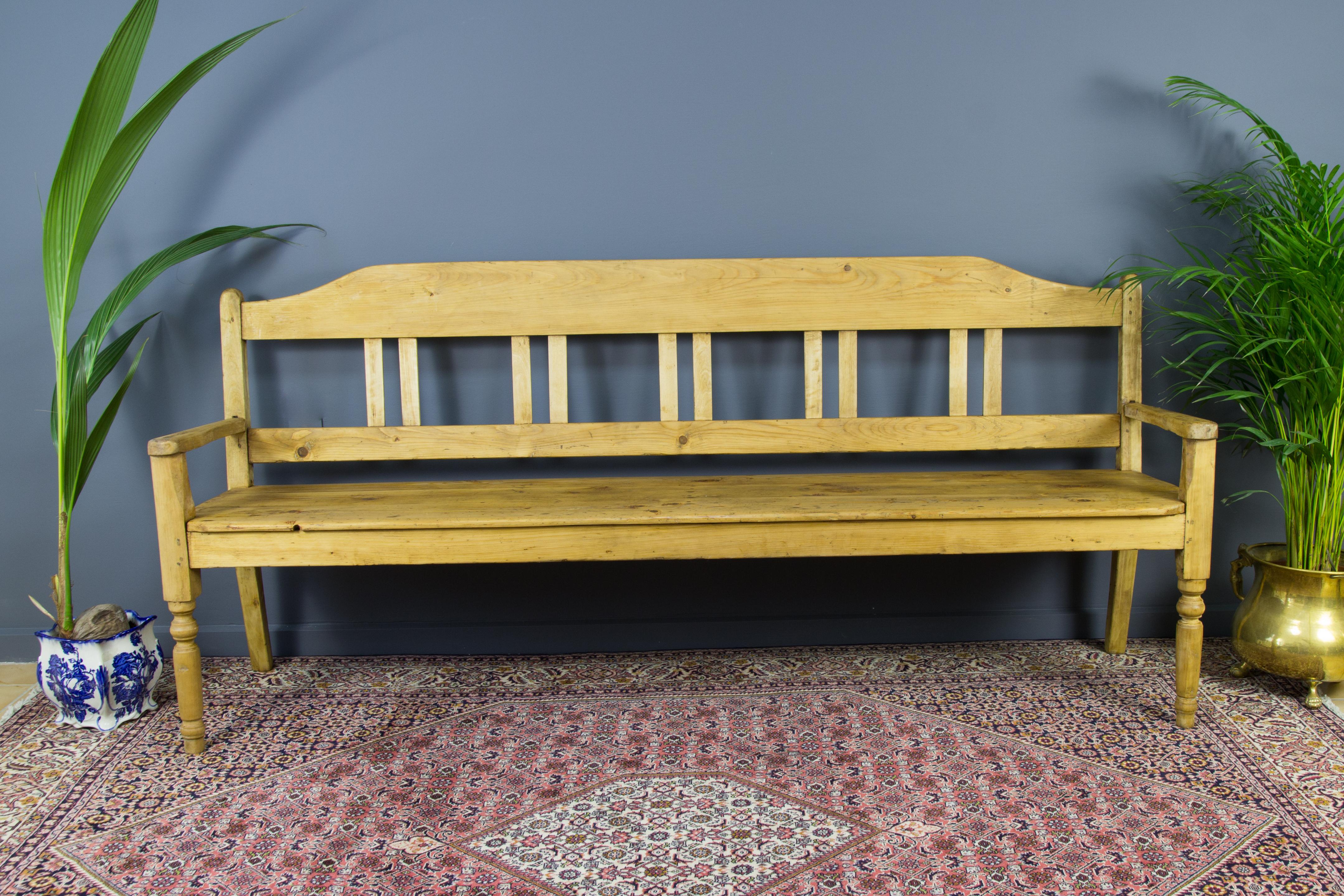 A large country style bench with backrest made of Baltic pine in circa 1920s. 
Dimensions: Height: 98 cm / 38.58 in; width: 218 cm / 85.82 in; depth: 51 cm / 20.07 in.
      