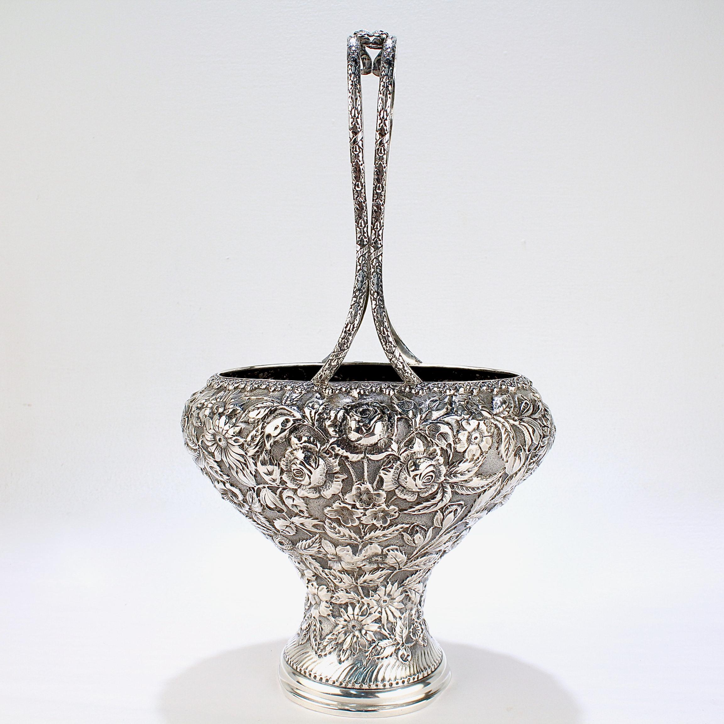 A fine antique sterling silver basket or vase. 

By the Baltimore Silversmiths Manufacturing Company.

With a repousse rose and flower decoration to the body and mounted with a twin ribbon handle to the top.

Bearing a monogram 'RML' to the