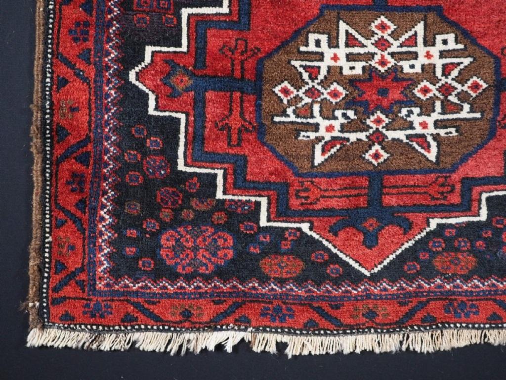 Antike Baluch-Satteltasche mit großem Medaillon-Motiv
CIRCA 1920

Die Satteltasche ist von der großen Medaillon-Design, das weiche Krapp rot Medaillon ist auf einem dunklen indigoblauen Feld, das mit Stammes-Geräte und Design-Elemente gefüllt ist