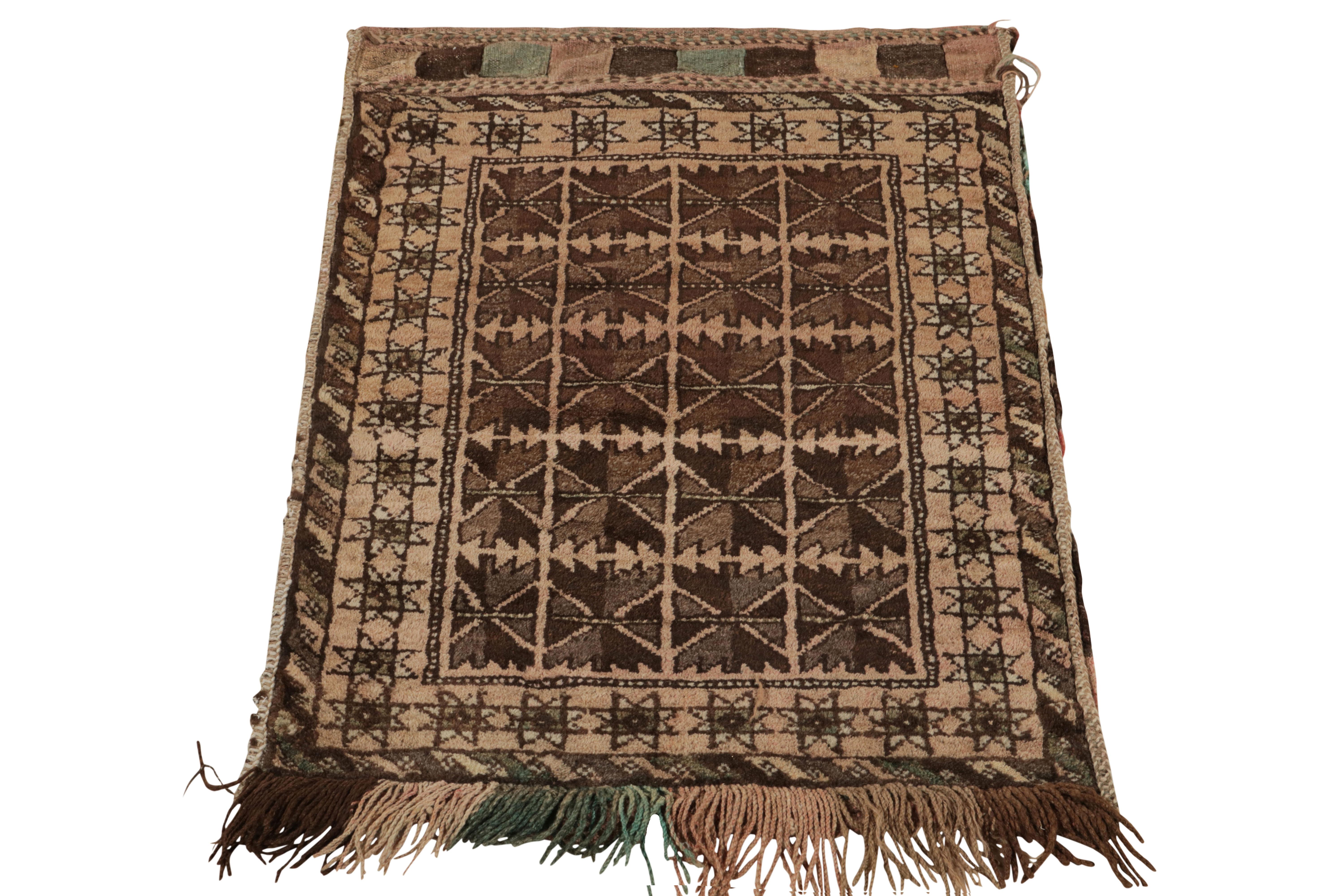 Paying tribute to the nomadic sensibilities of Baluchistan, a 2x3 antique Baluch rug coming from Persia circa 1920-1930. The hand-knotted wool rug displays a tribal geometric pattern in brown-beige for exceptional pagination on scale. The fine