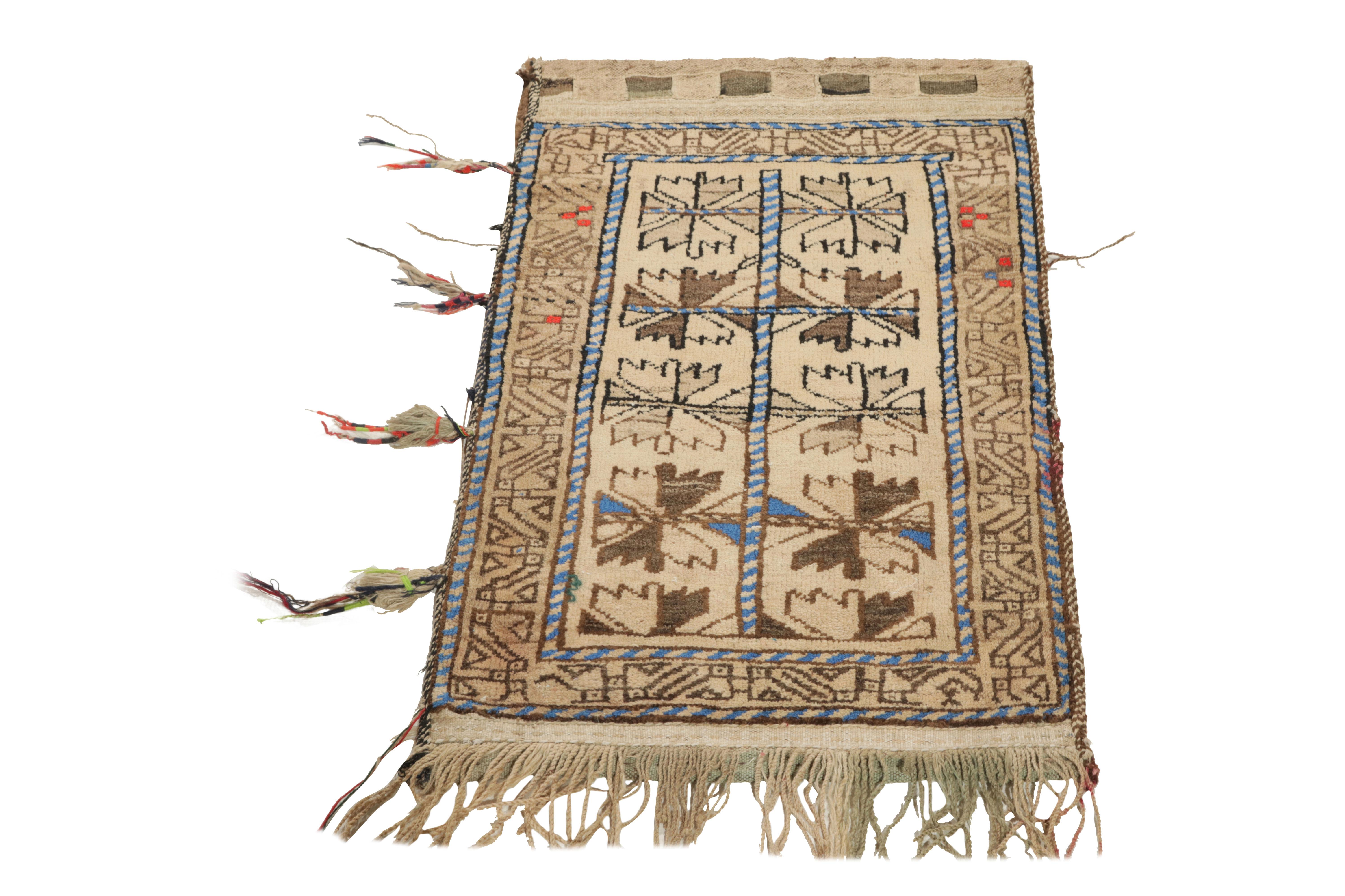 An ode to the nomadic sensibilities of Baluchistan, a 2x3 antique Baluch rug originating from Persia circa 1920-1930. The rustic imagination features a geometric pattern in brown & blue blending seamlessly with traditional motifs on the border - all