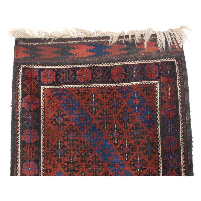 Antique Baluch rug from Western Afghanistan, probably Timuri tribe.

A superb Baluch rug with a fine diamond lattice design, the bright indigo blue diagonal lattice is really outstanding. The rug has a scarce border design on a charcoal coloured